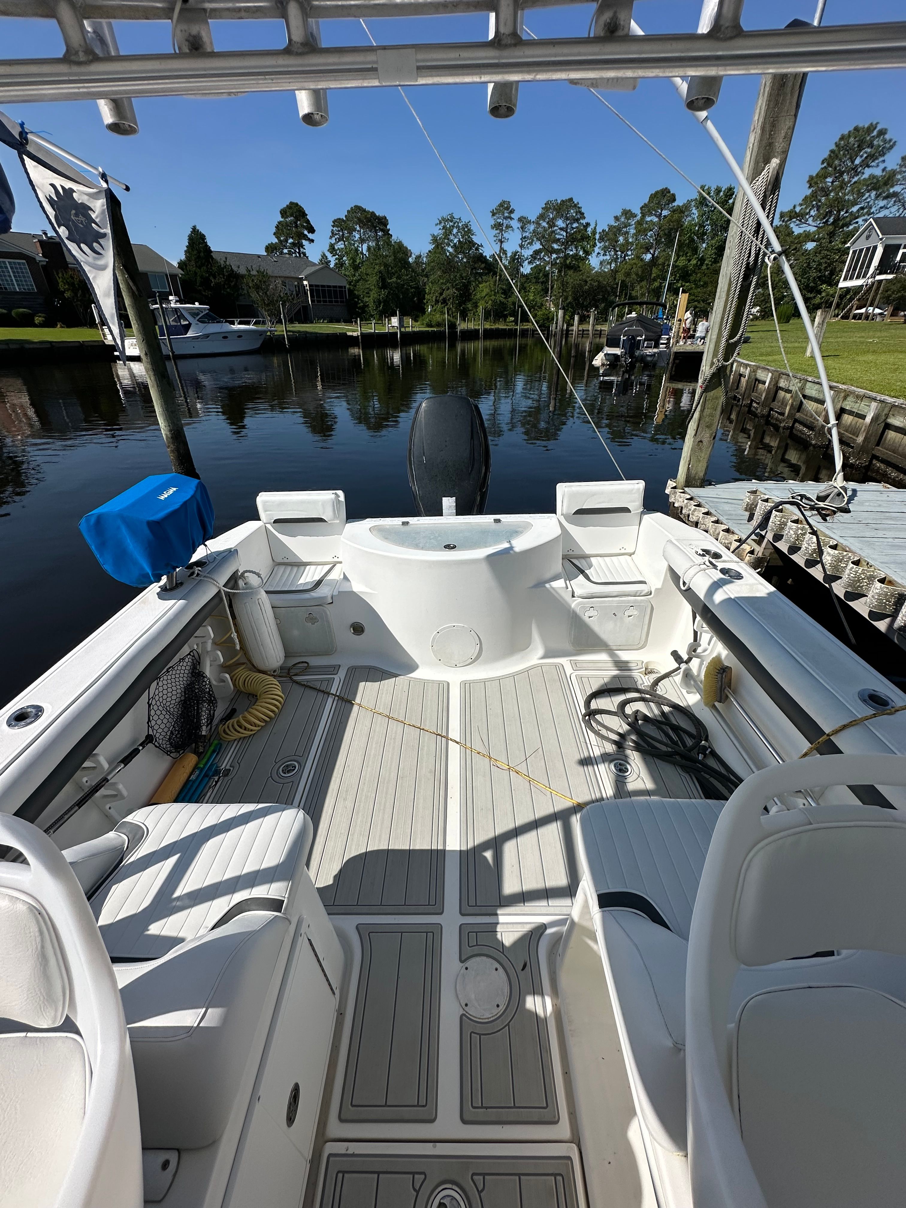 The image shows the cockpit of a 2009 Sea Fox 256WA boat docked in a calm marina.