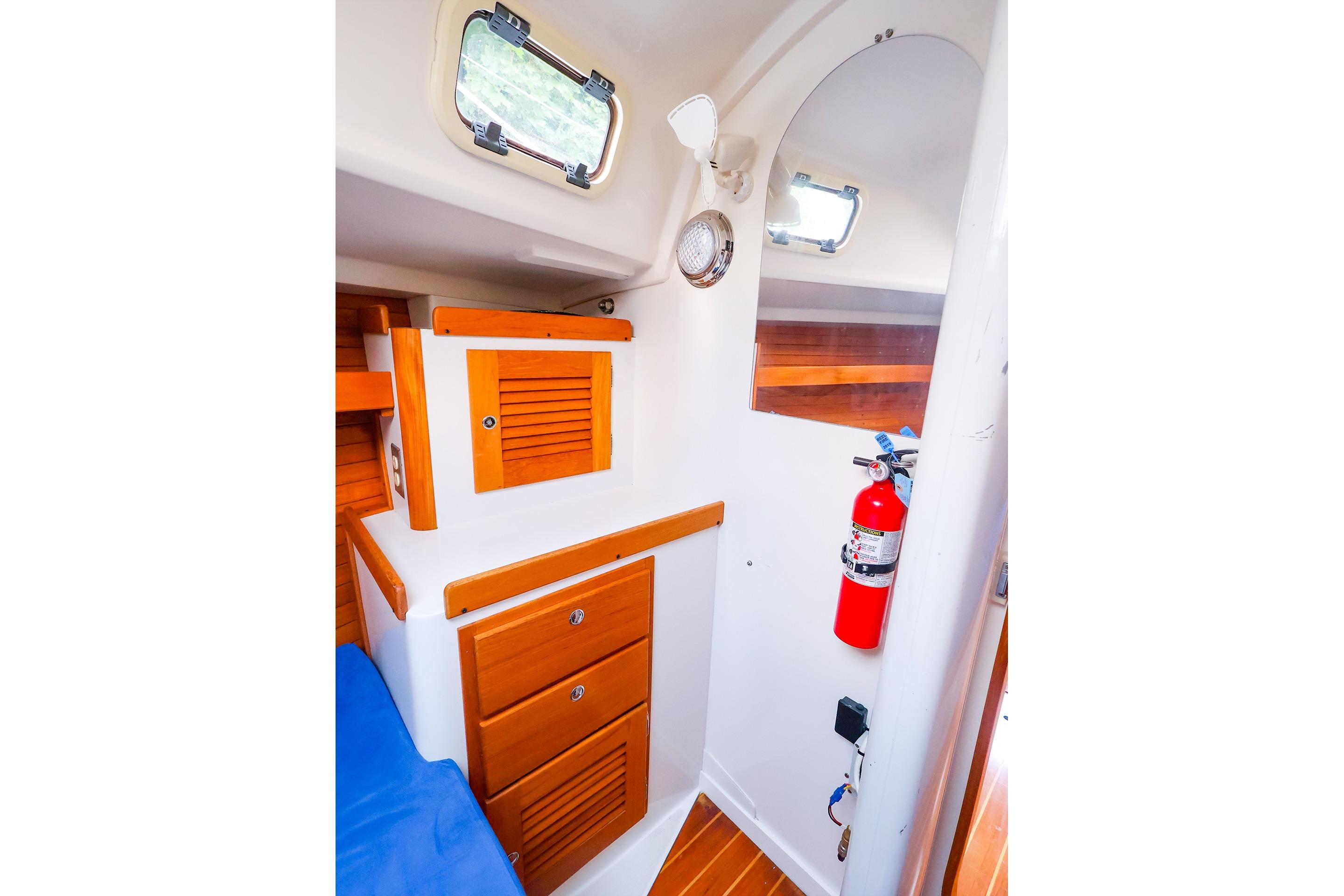 Interior of 2001 J Boats J/32 sailboat with wooden cabinets and fire extinguisher.