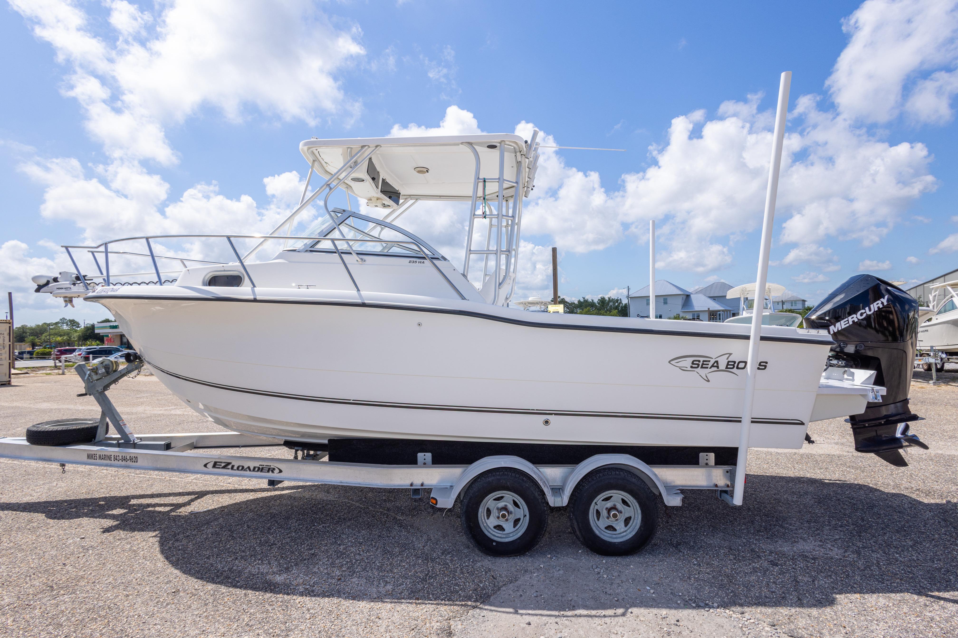 2007 Sea Boss 235 Walkaround boat on trailer under a clear blue sky.