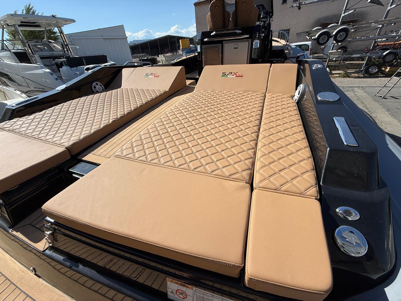 2024 SPX RIB 38 boat with tan quilted seating, docked outdoors.
