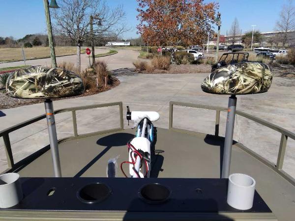 2024 Tracker Grizzly 2072 CC Sportsman boat with camo seats and fishing rod holders.