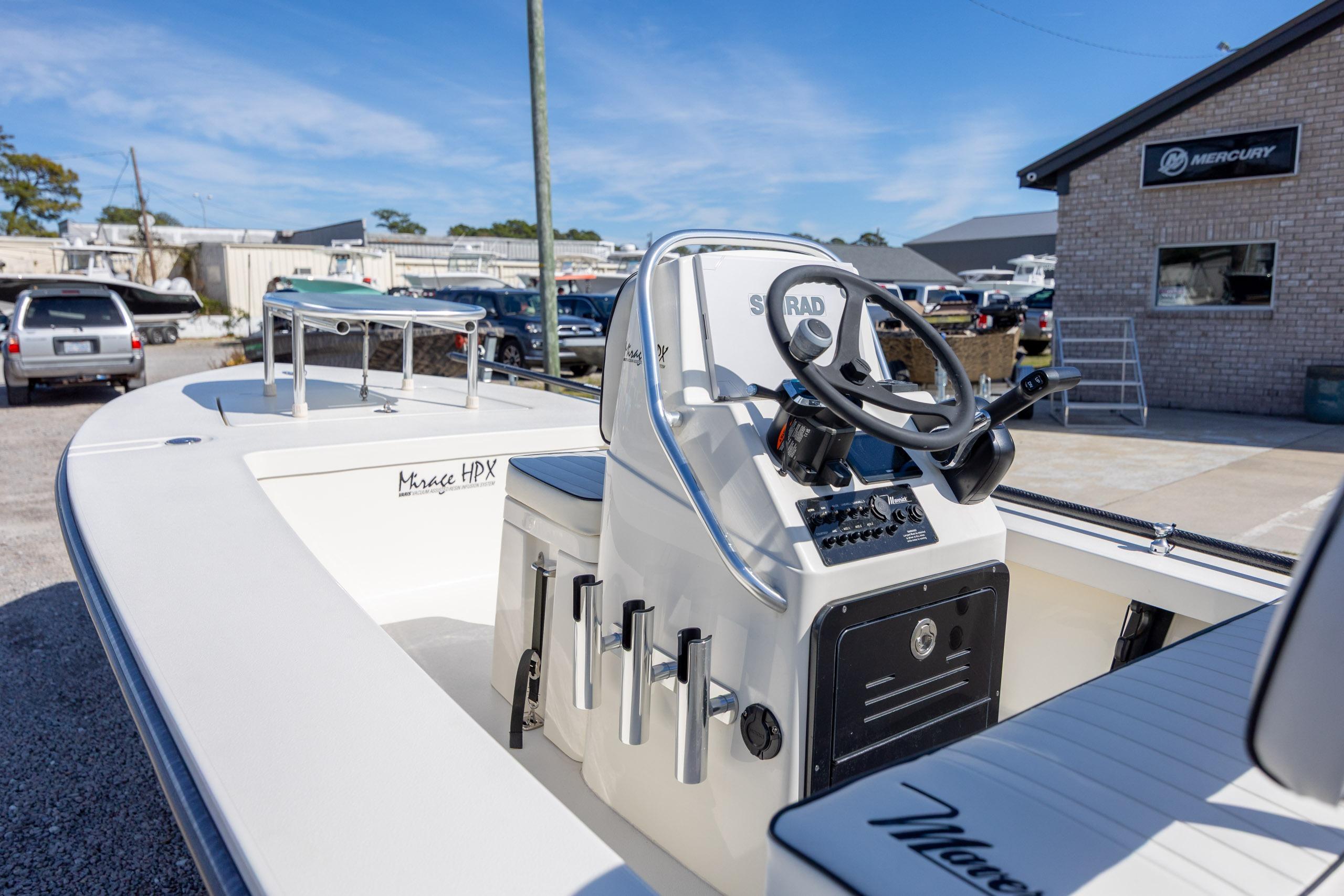 2024 Maverick 17 HPX-S boat with steering console, parked outdoors near Mercury building.