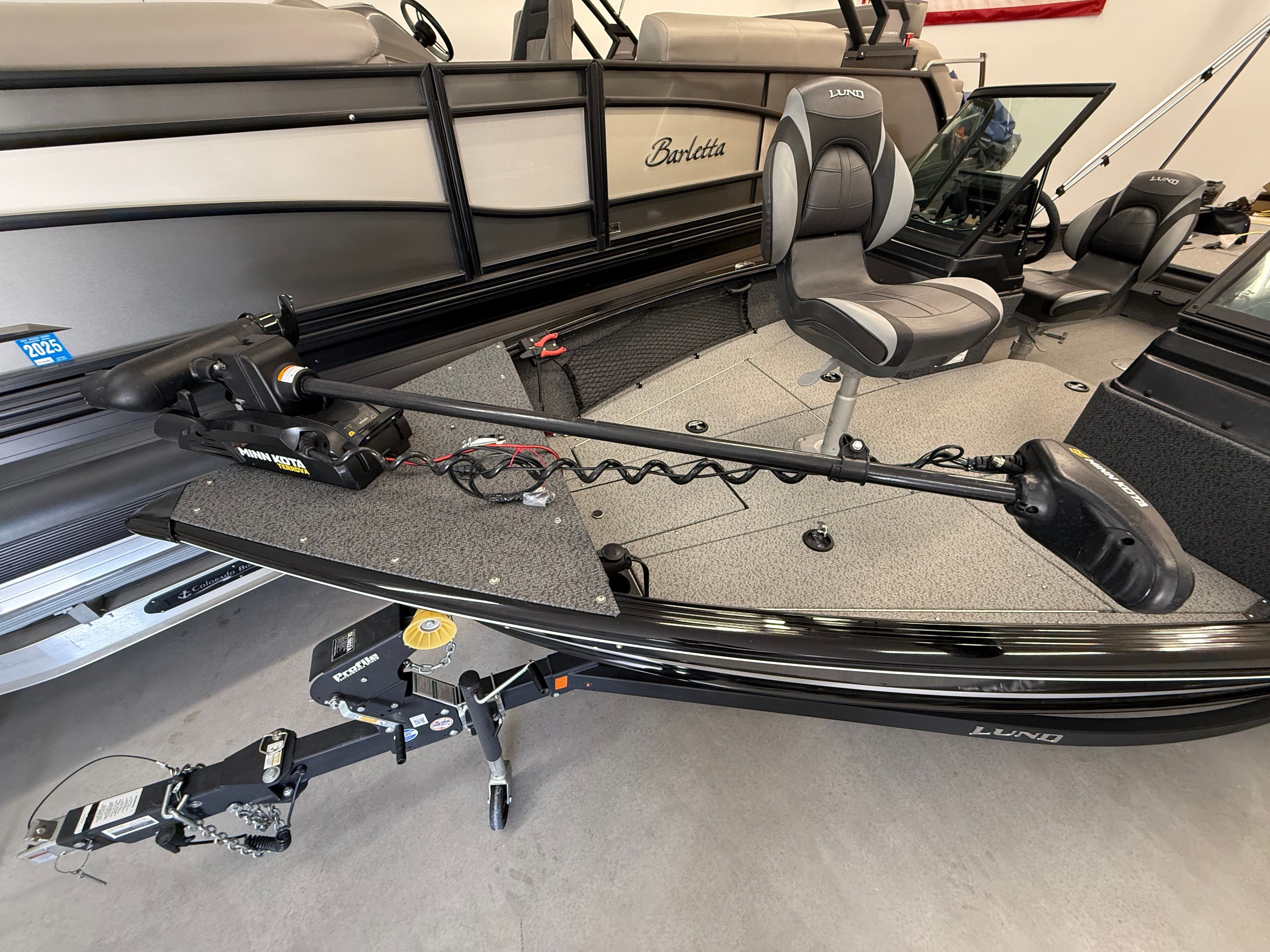 The image shows a Lund 1875 Impact XS Sport boat with a modern helm and seating.