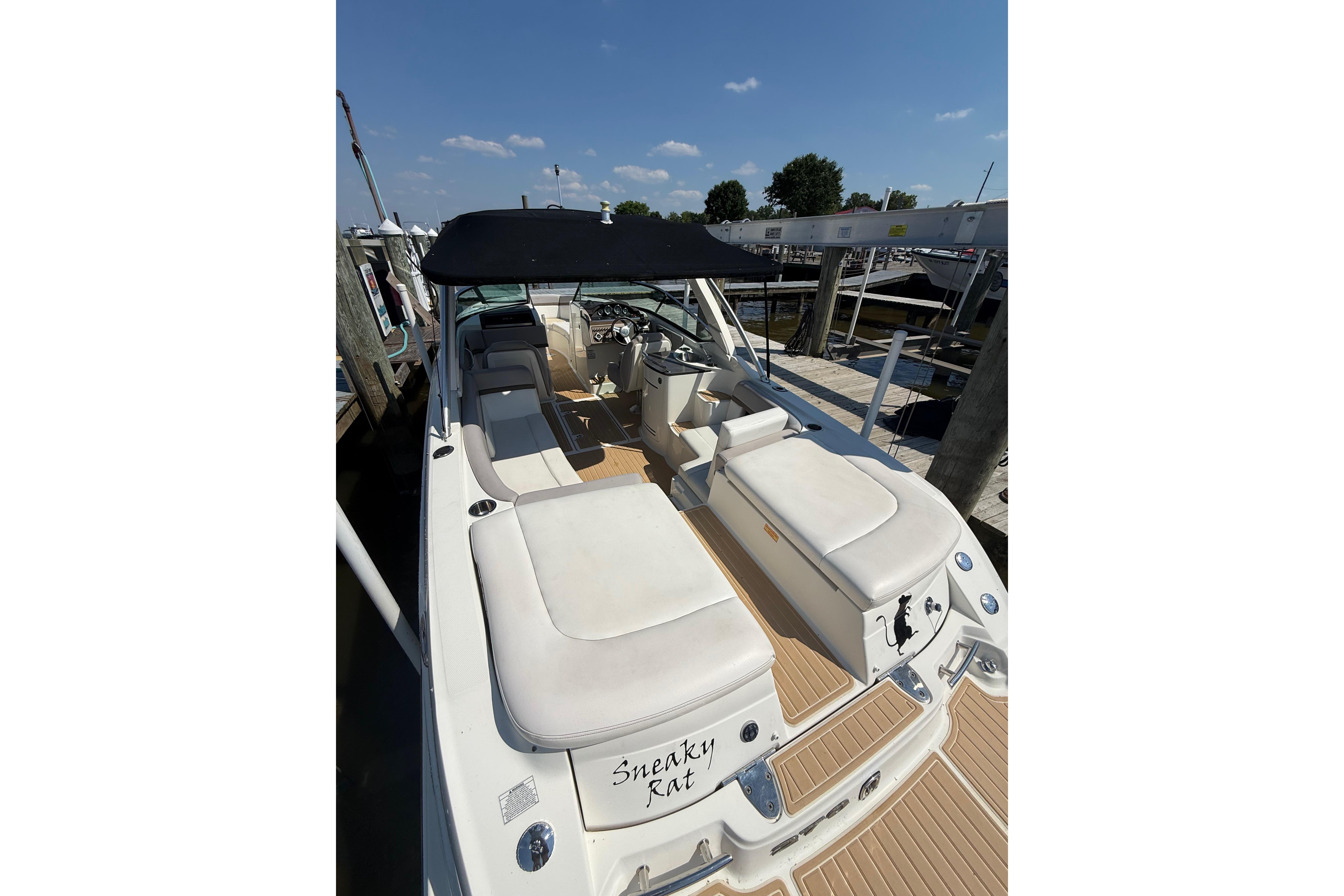 2011 Sea Ray 270 SLX boat with white seating and black canopy at dock.