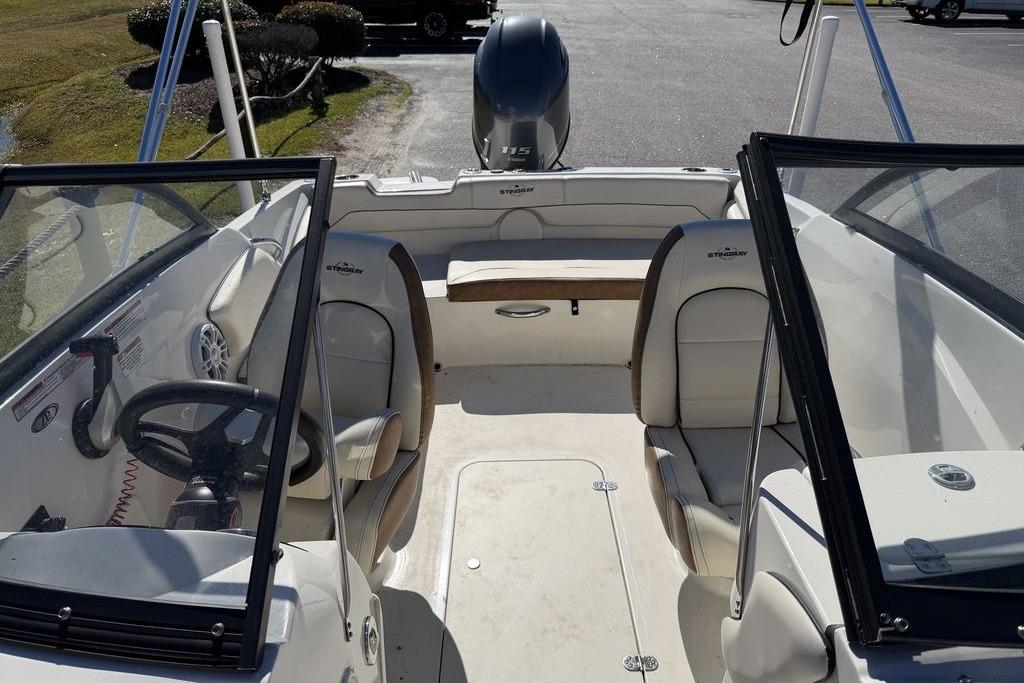 2024 Stingray 191 DC boat interior with seating and steering wheel, parked outdoors.