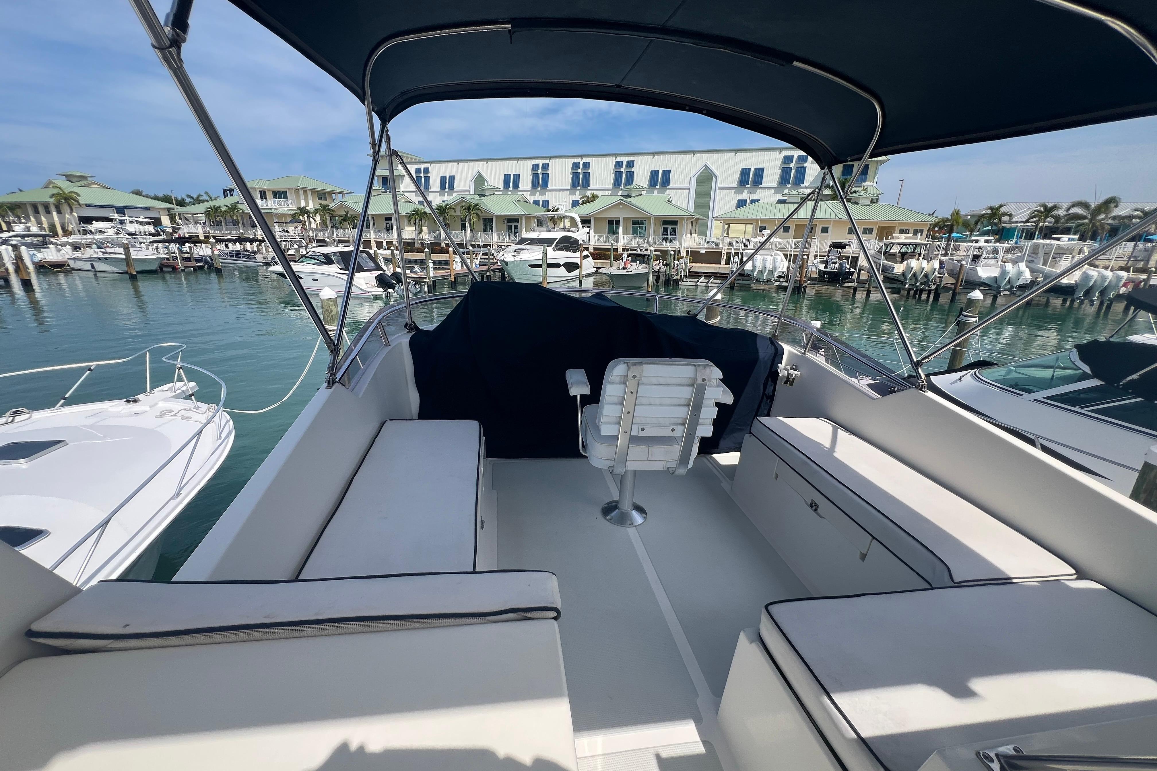 Flybridge of 2007 Heritage East 36 Sundeck Trawler at marina, featuring seating and canopy.