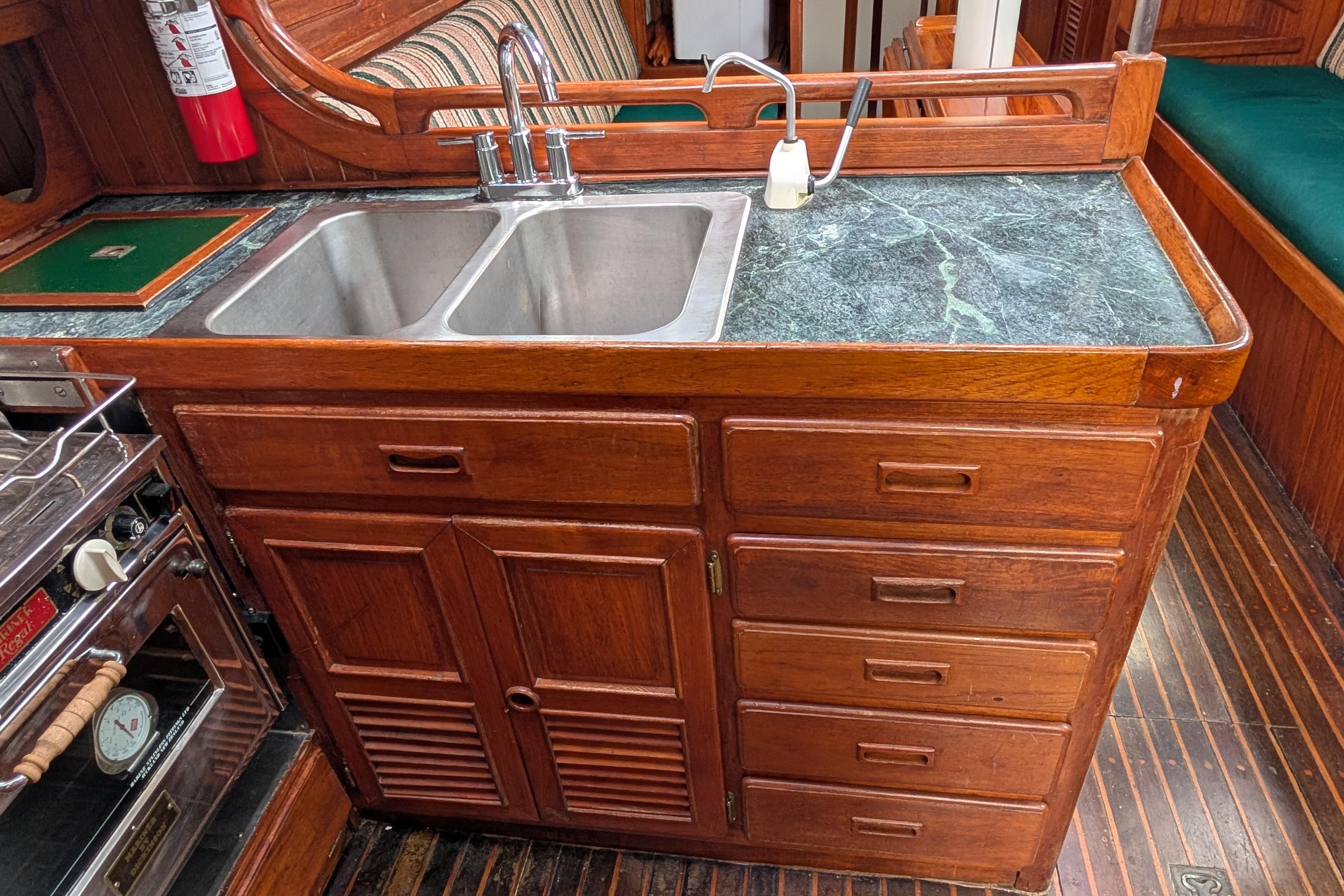 Wooden kitchen galley with double sink in 1983 Perry 41 yacht.