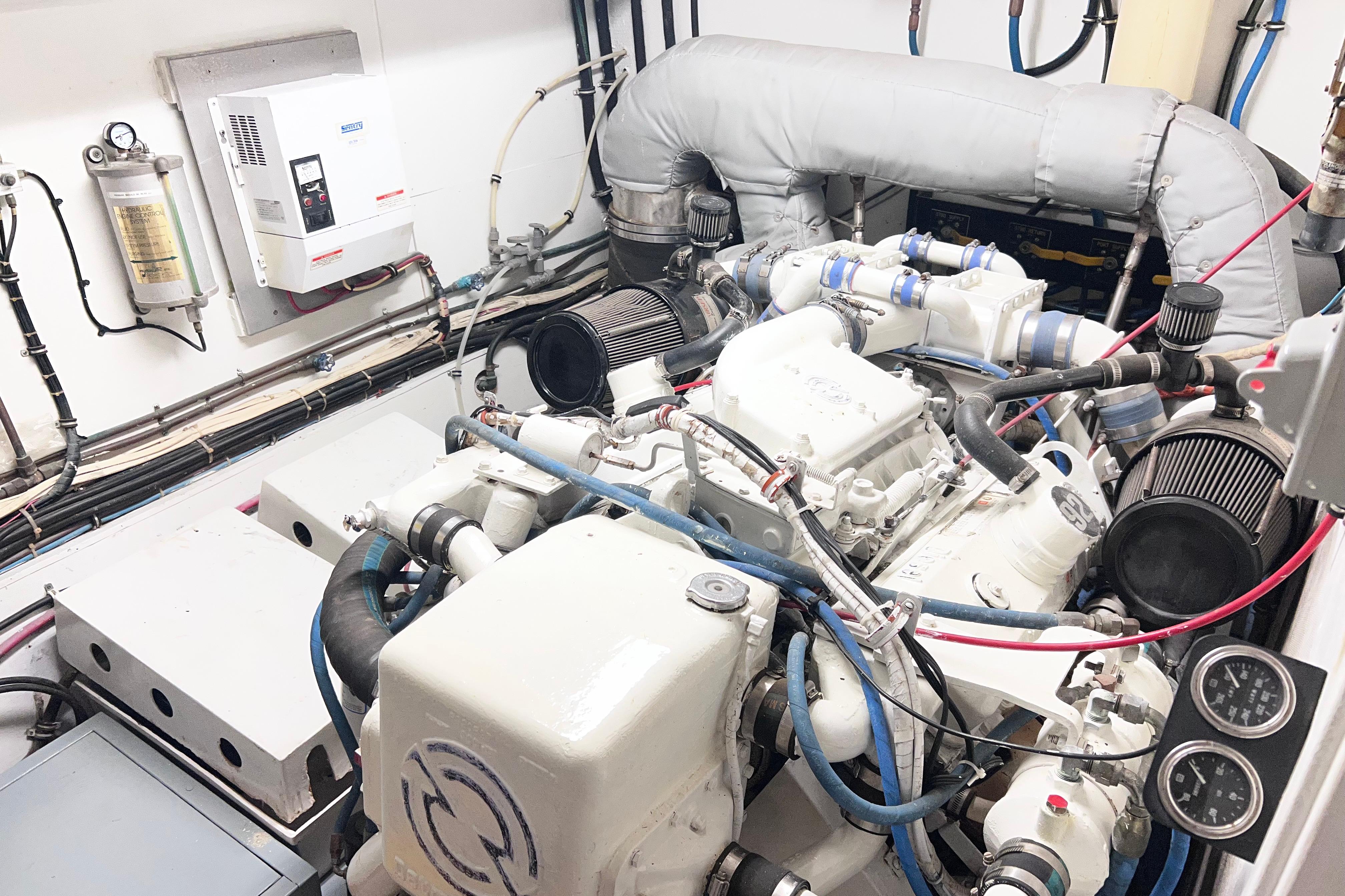 Engine room of 1987 Hatteras 70 Cockpit Motor Yacht, showcasing mechanical components.