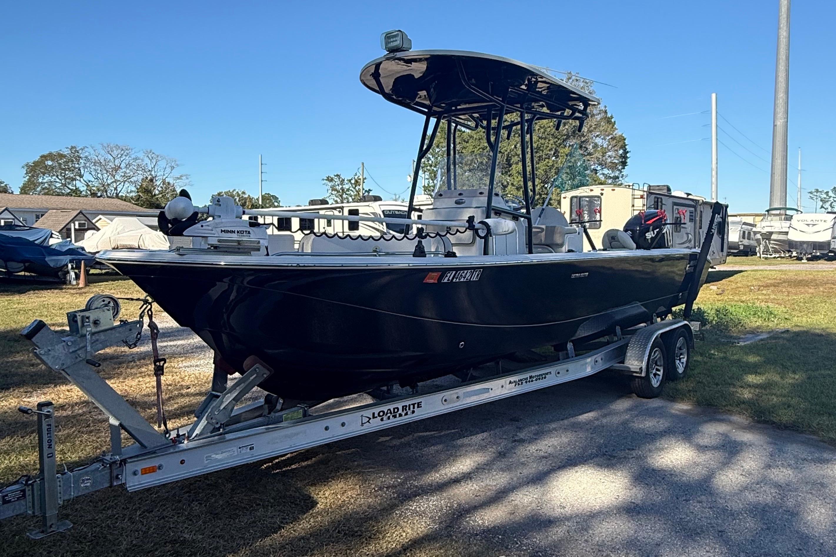 2021 Carolina Skiff 26 Ultra Elite boat on trailer, parked outdoors.