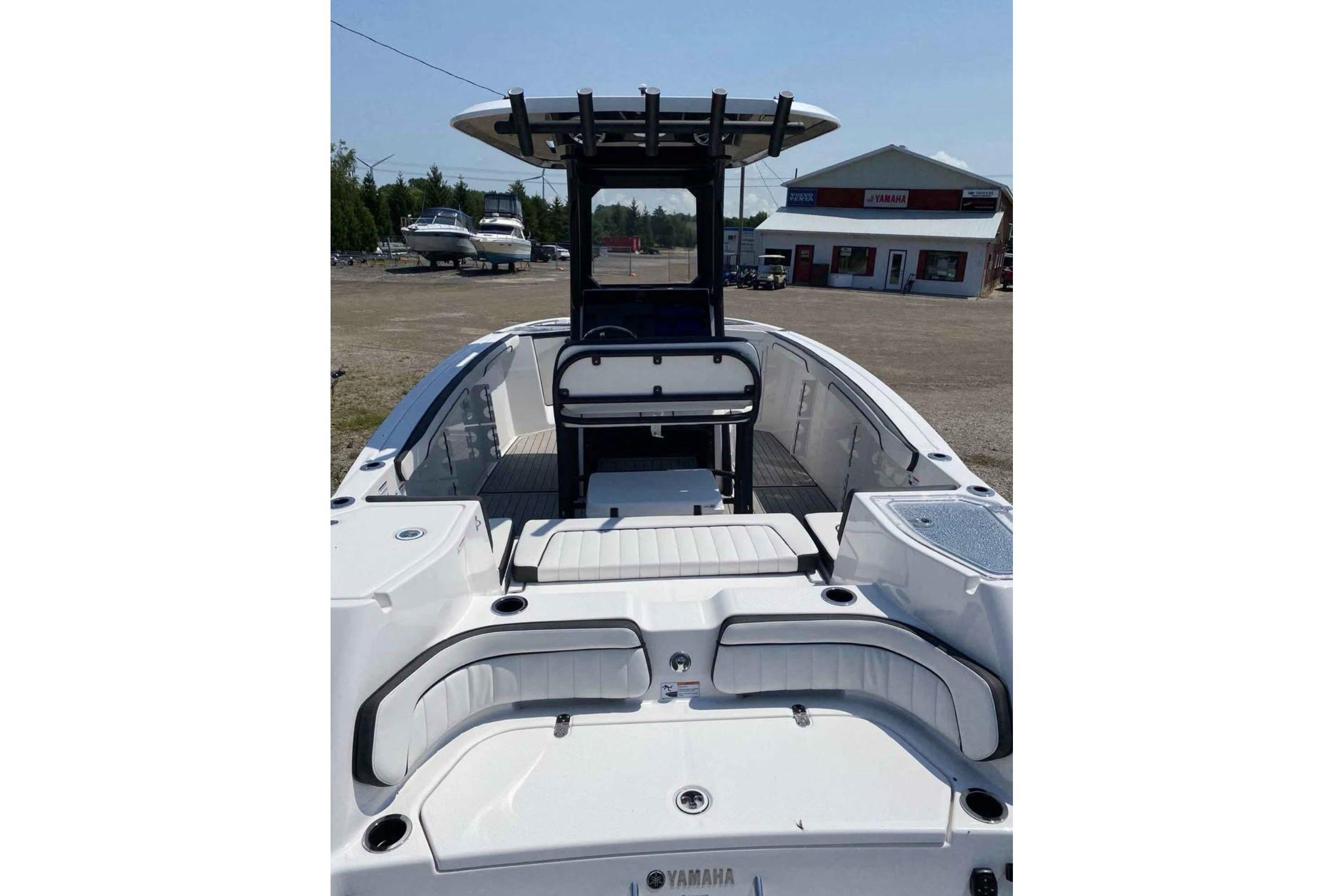 2022 Yamaha 255 FSH boat with seating and T-top, displayed outdoors.