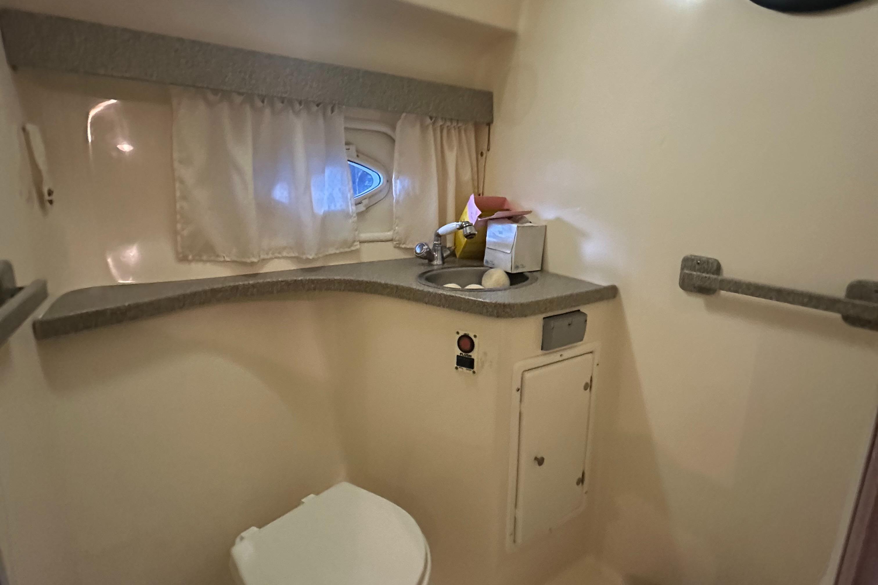 2003 Rinker Fiesta Vee 312 boat bathroom with sink, toilet, and window.