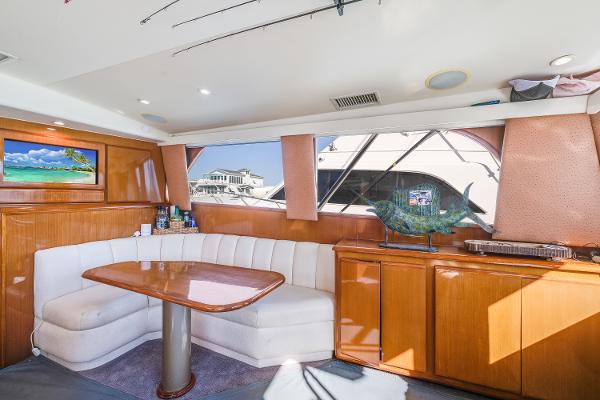 Interior of 1999 Viking 47 Convertible yacht with dining area and scenic window view.