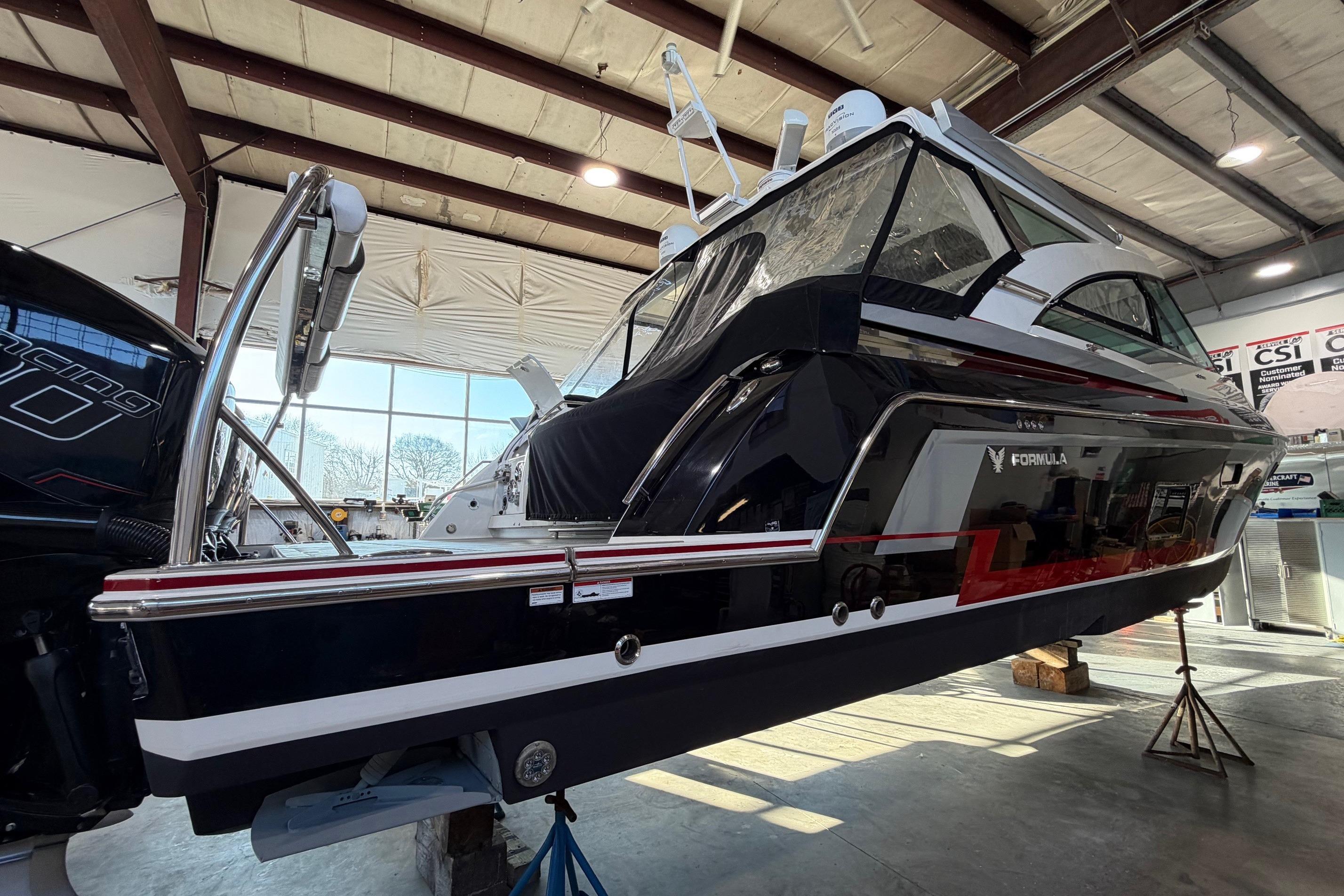 2017 Formula 430 Super Sport Crossover boat in a warehouse, side view.