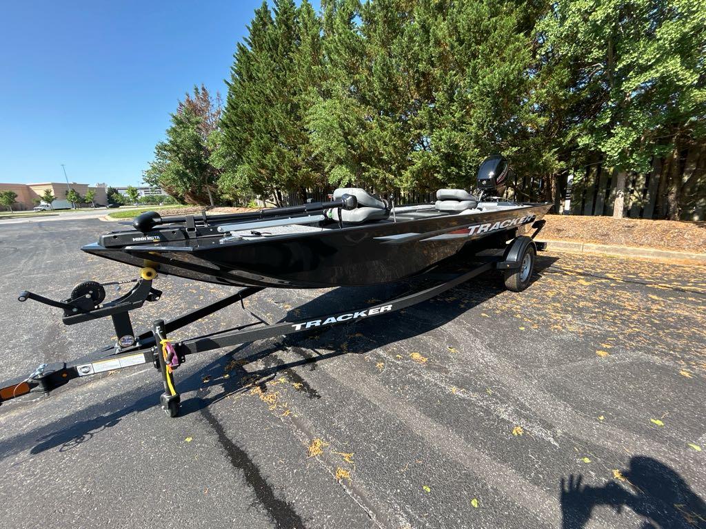 2025 Tracker Panfish 17 boat on trailer, parked in sunny lot with trees.