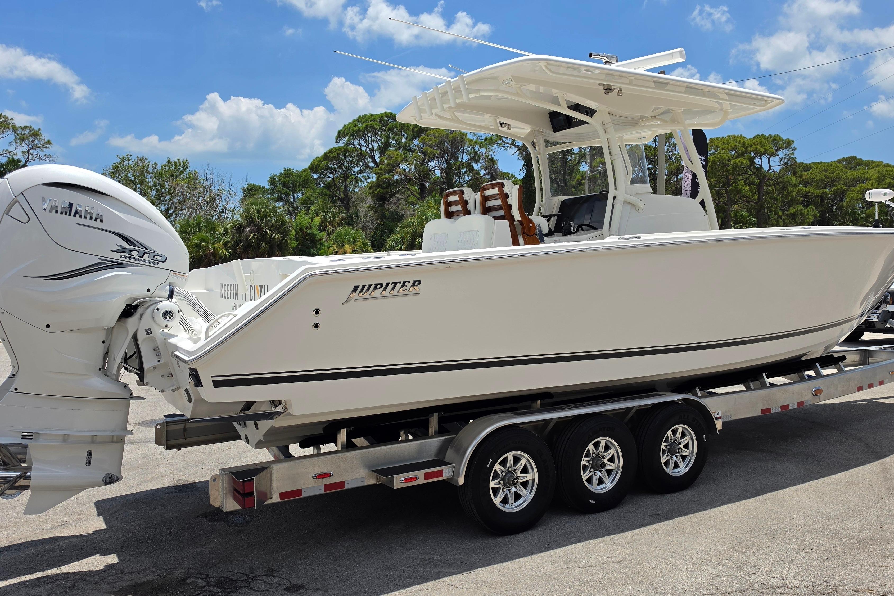 2020 Jupiter 34 HFS boat on trailer with Yamaha engine, under clear blue sky.