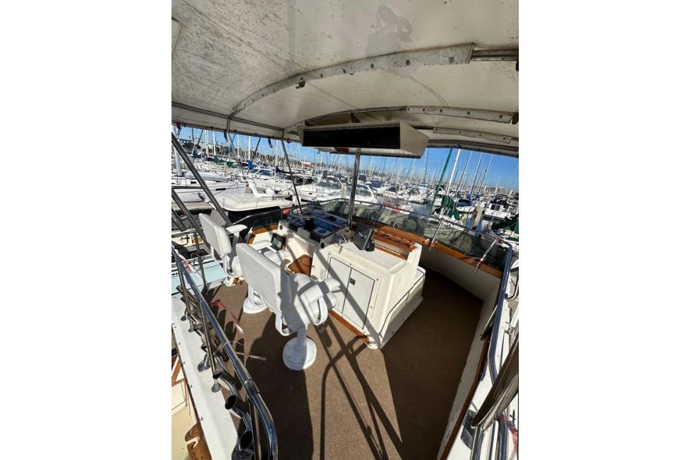 1985 Egg Harbor 33 Sedan boat interior with helm, marina view, and seating area.