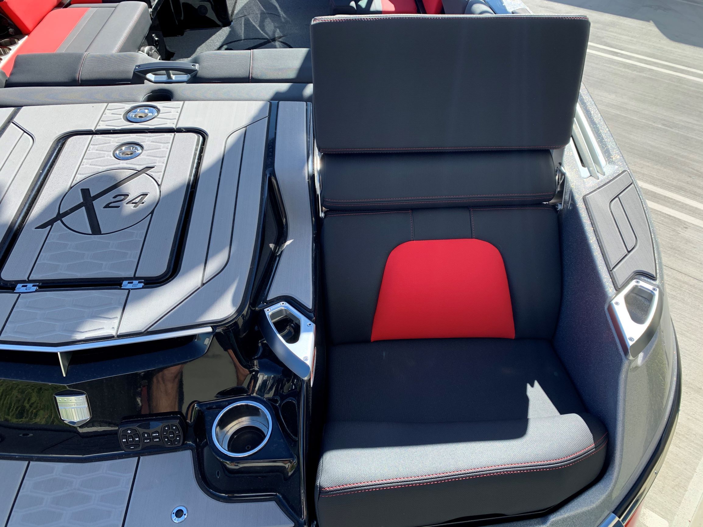 The image shows the seating area of a 2020 MasterCraft X24 boat with gray and red upholstery.