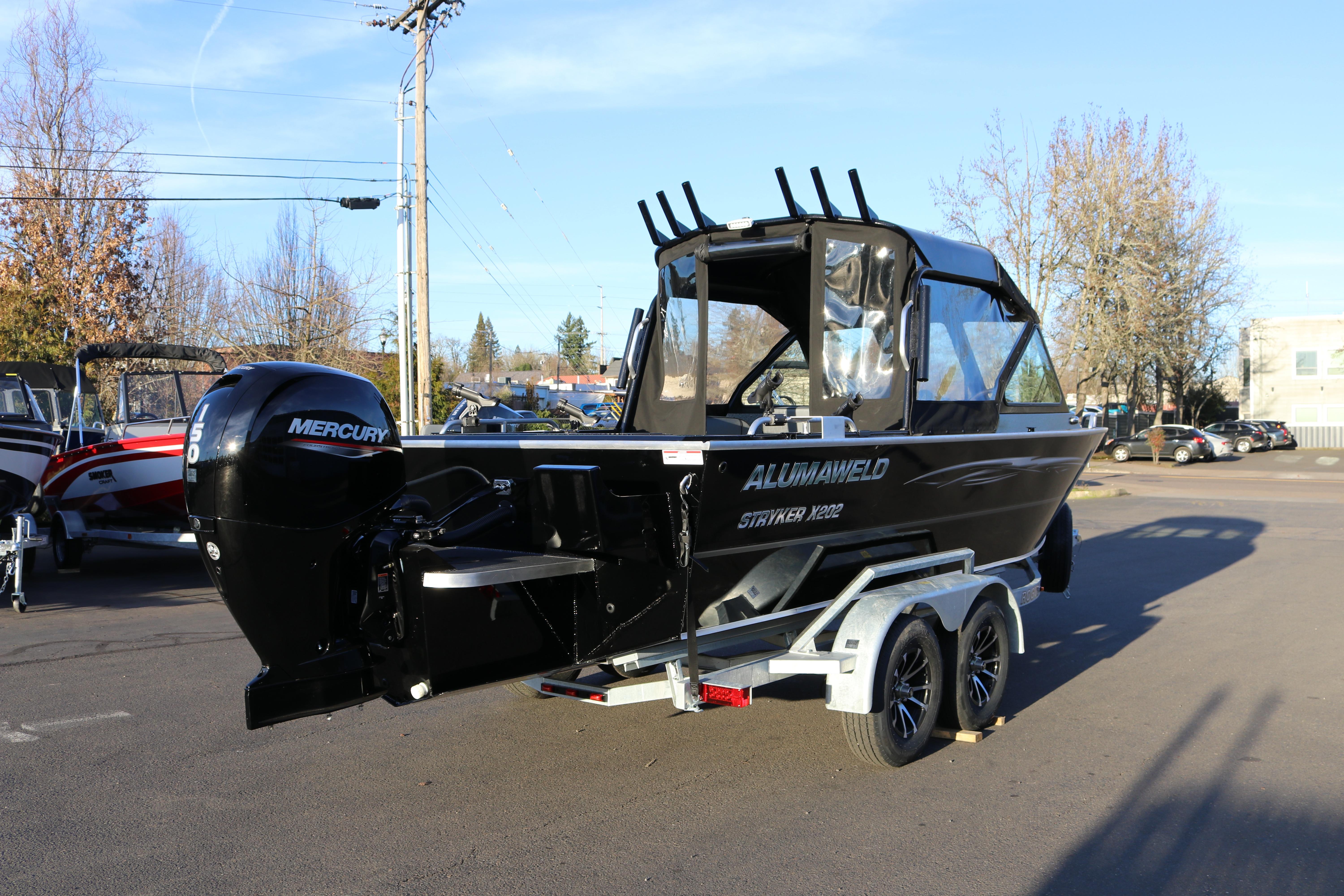 2026 Alumaweld Stryker X202 boat with Mercury engine on trailer in parking lot.