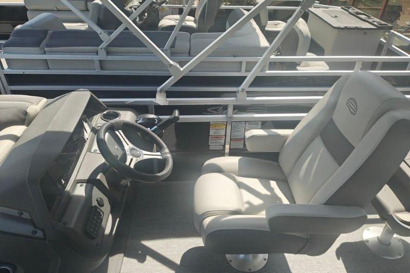 2026 Sun Tracker Fishin' Barge 20 DLX interior with steering wheel and seating.