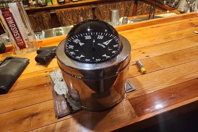 Large nautical compass on a wooden bar counter, Bristol 45.5 Center Cockpit, 1984.