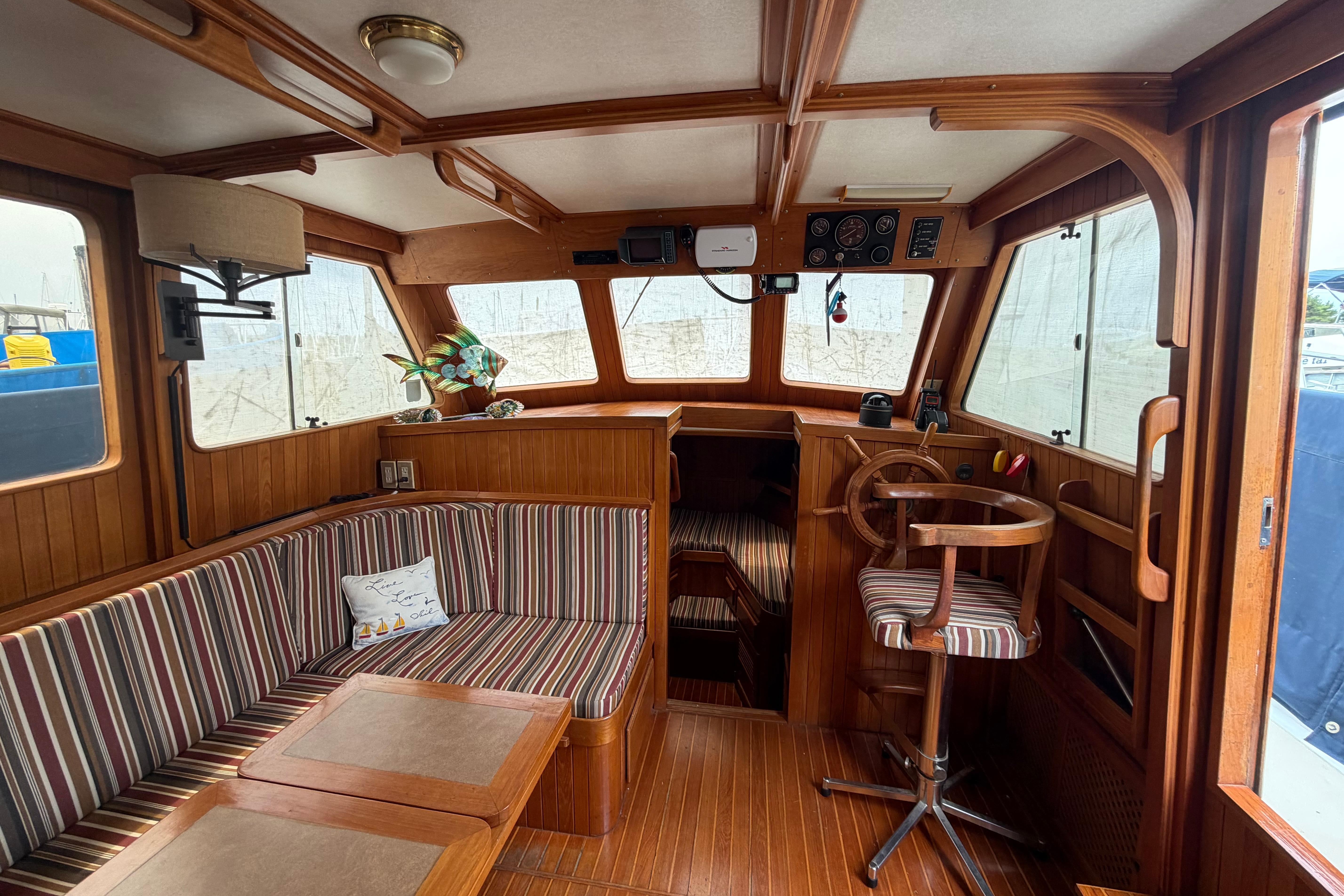 Interior of a 1988 Monk 36 boat with wood paneling and striped seating.