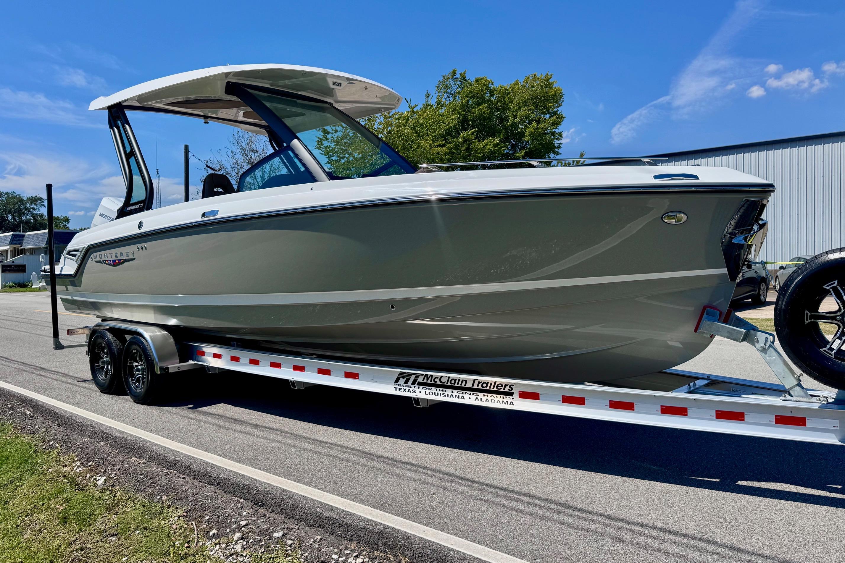 2026 Monterey Elite 27 OB boat on trailer, parked on a sunny day.
