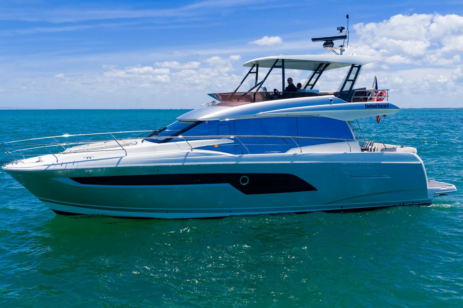 2022 Prestige 520 yacht cruising on clear blue ocean under sunny skies.