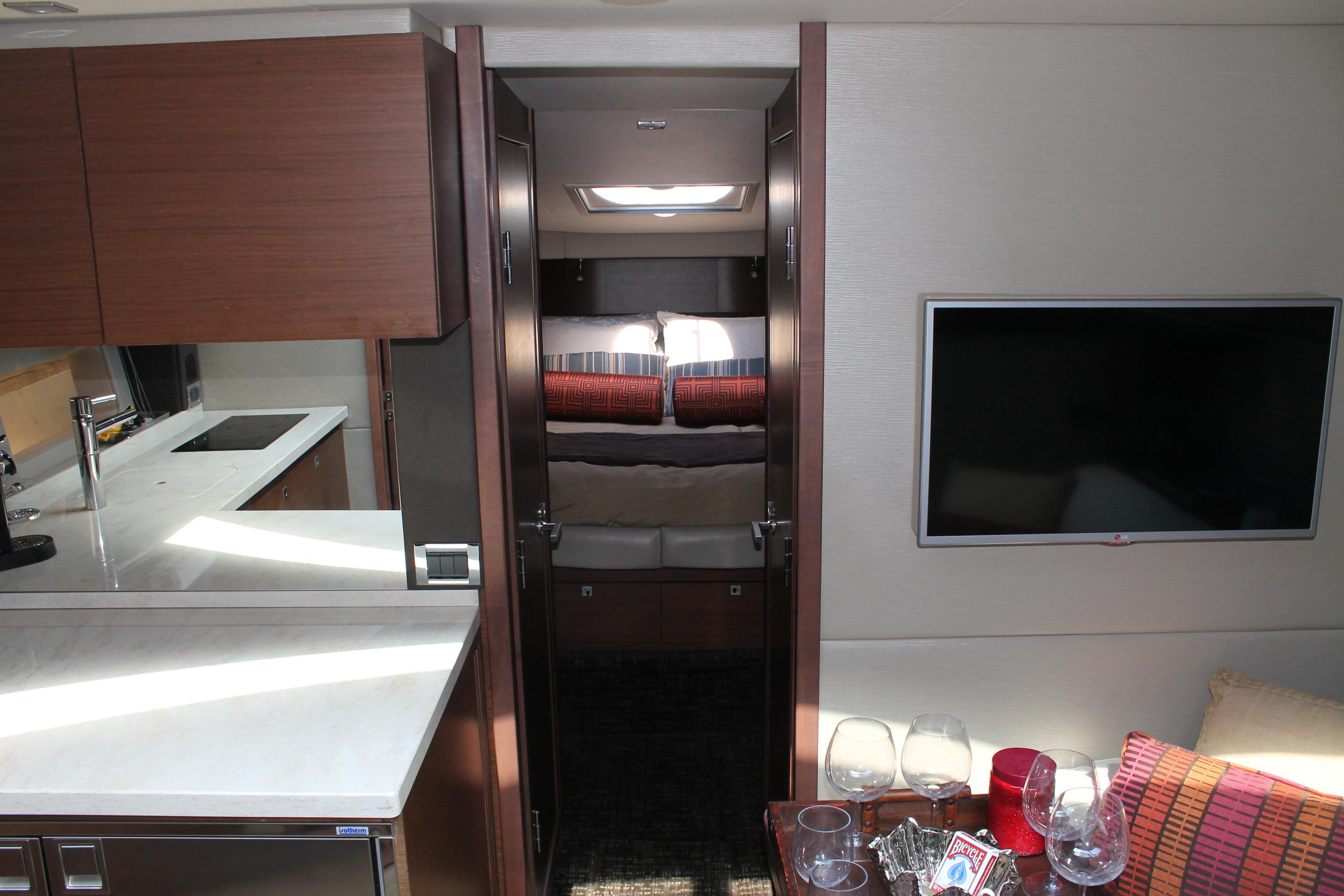 Luxurious interior of 2015 Sea Ray 470 Sundancer yacht with modern kitchen and cozy seating area.