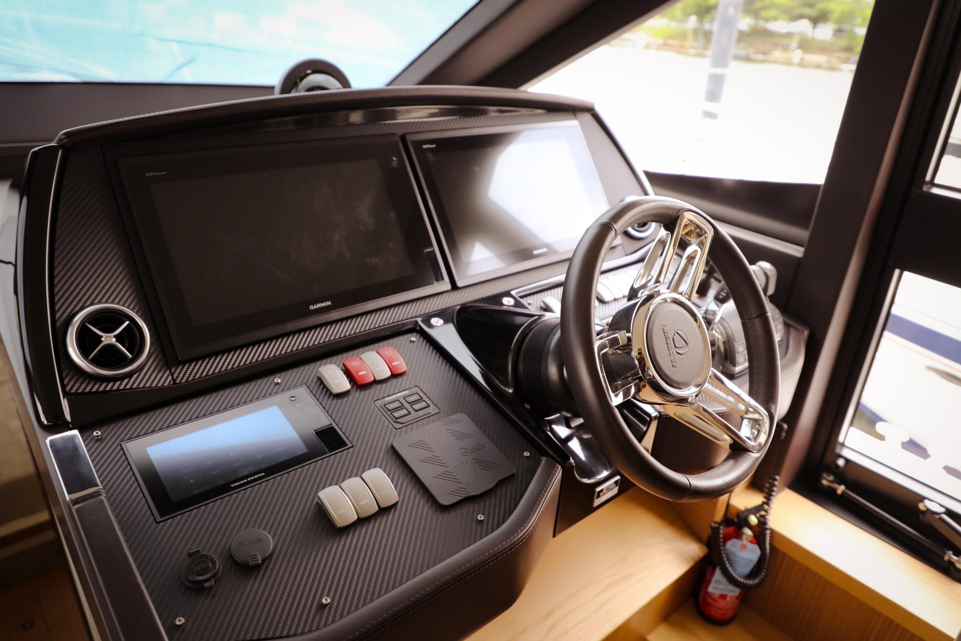 Control panel of a 2019 Absolute 50 Fly yacht with modern steering and displays.