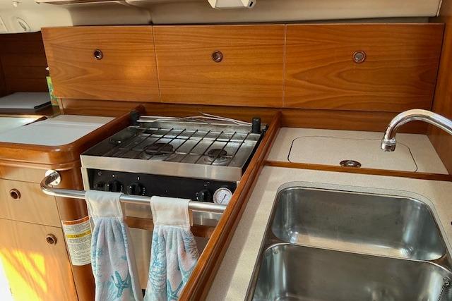 Kitchen area of 2000 Beneteau Oceanis 321 yacht with stove and sink.