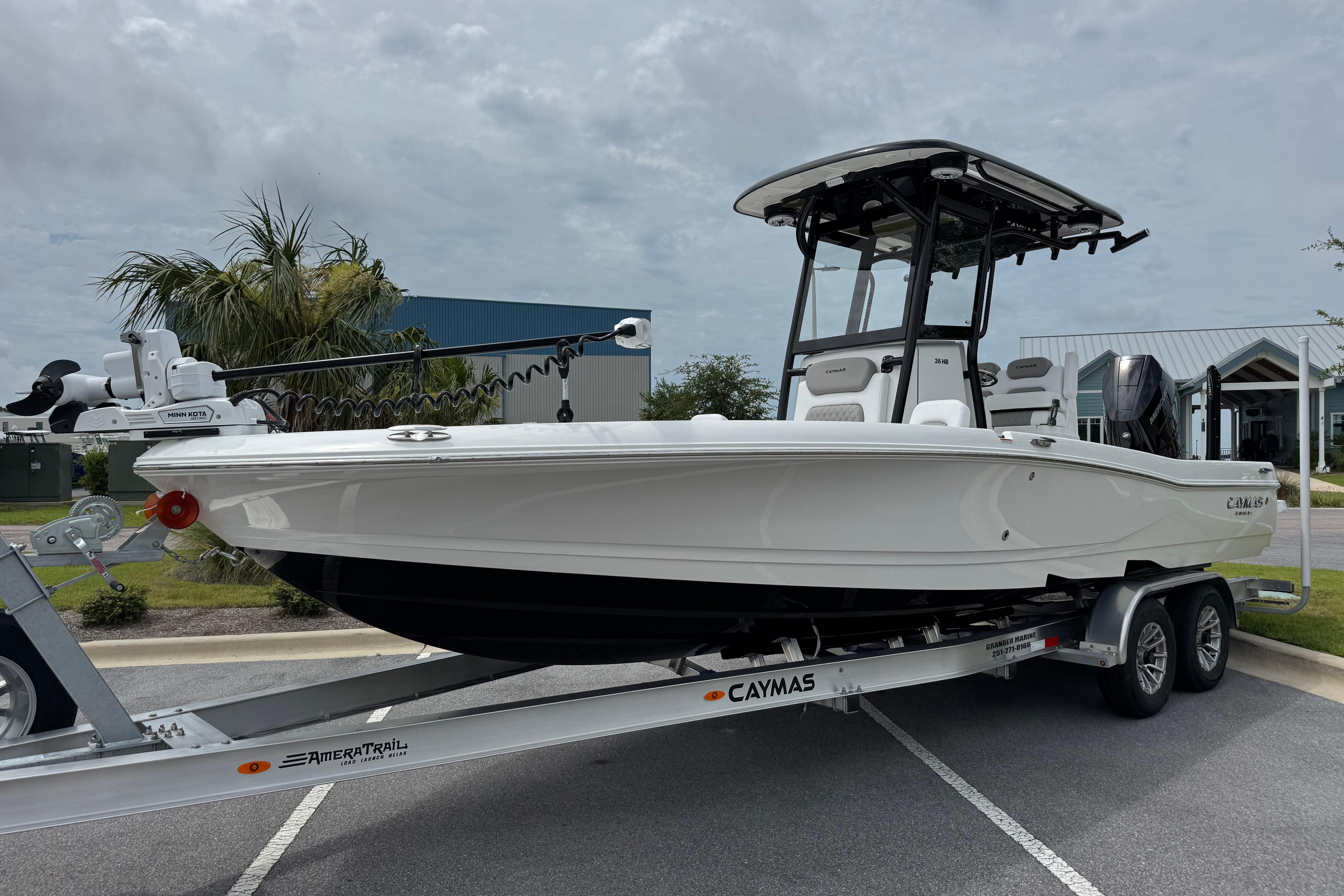 2027 Caymas 26 HB boat on trailer, parked outdoors under cloudy sky.