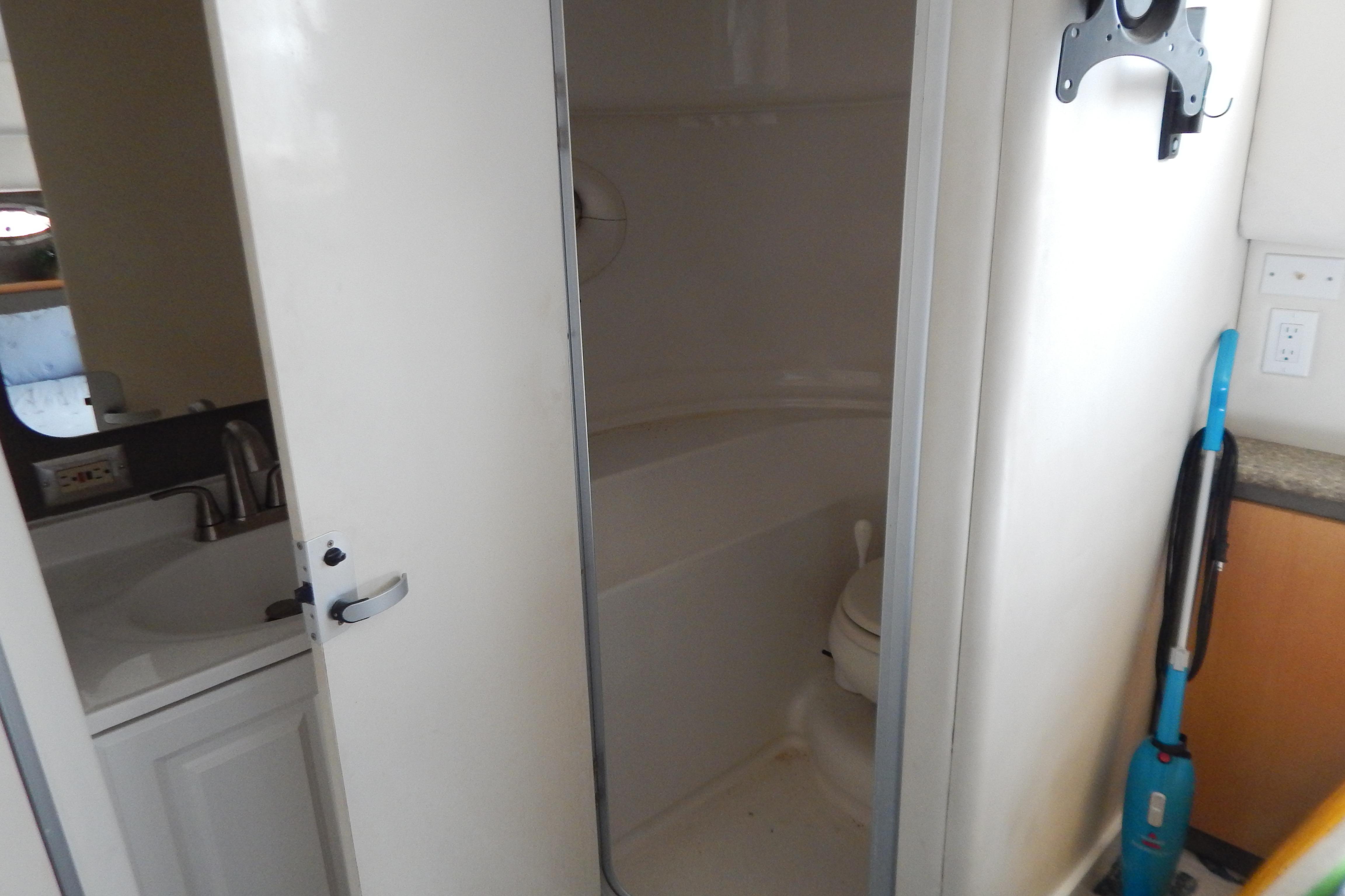 Compact bathroom in a 1998 Magnum 4100 SCR boat, featuring a sink and toilet.
