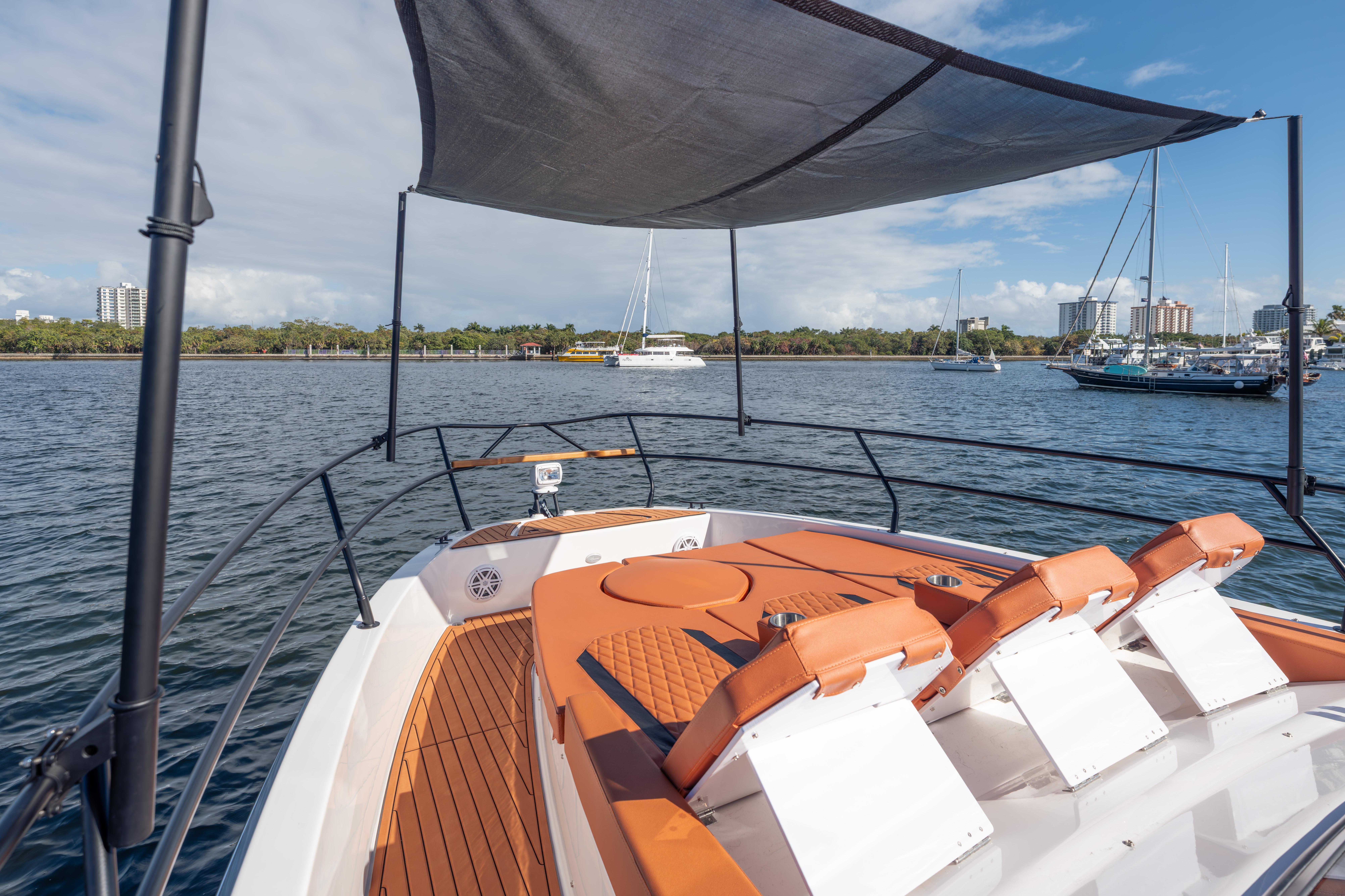 Luxury Hanover 387 boat, 2026 model, with sunshade and seating, docked in a scenic marina.