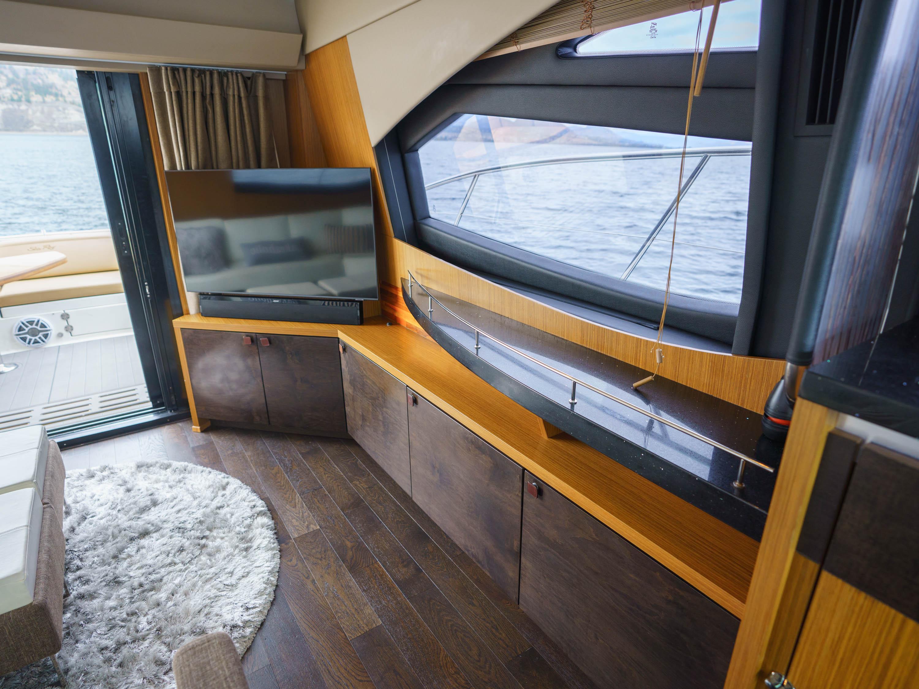 Luxurious interior of 2016 Sea Ray L590 yacht with modern furnishings and large windows.