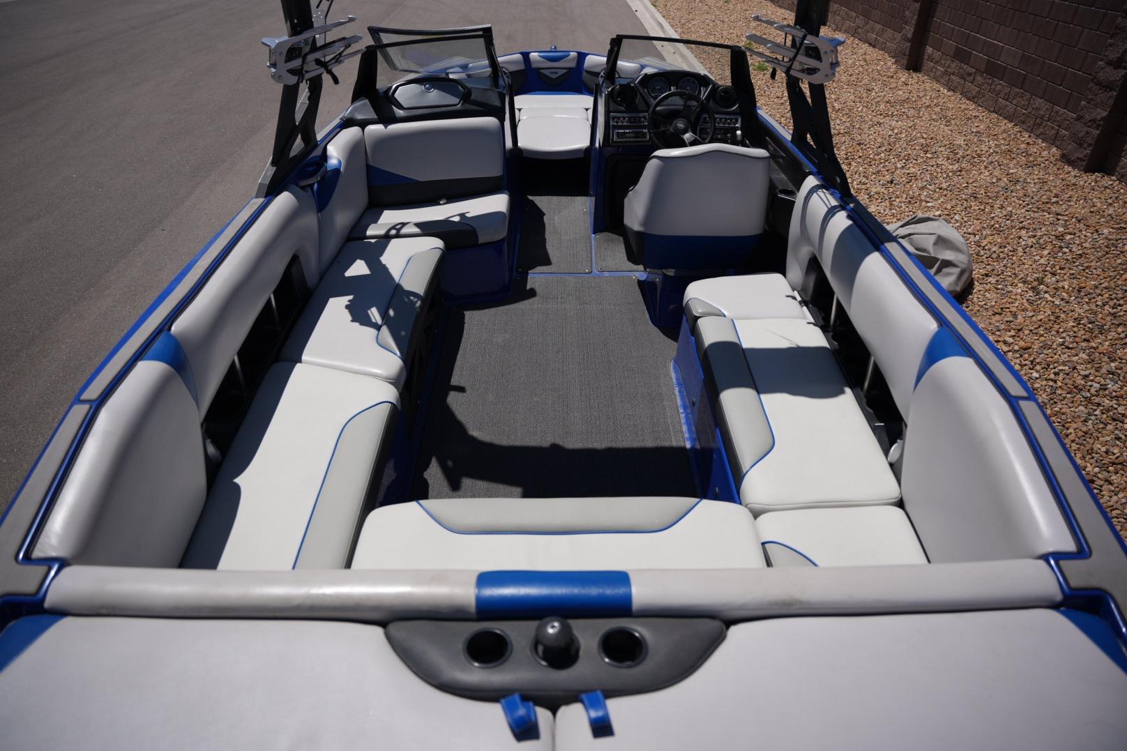 2015 Axis A24 boat interior with blue and white seating, steering wheel, and dashboard.