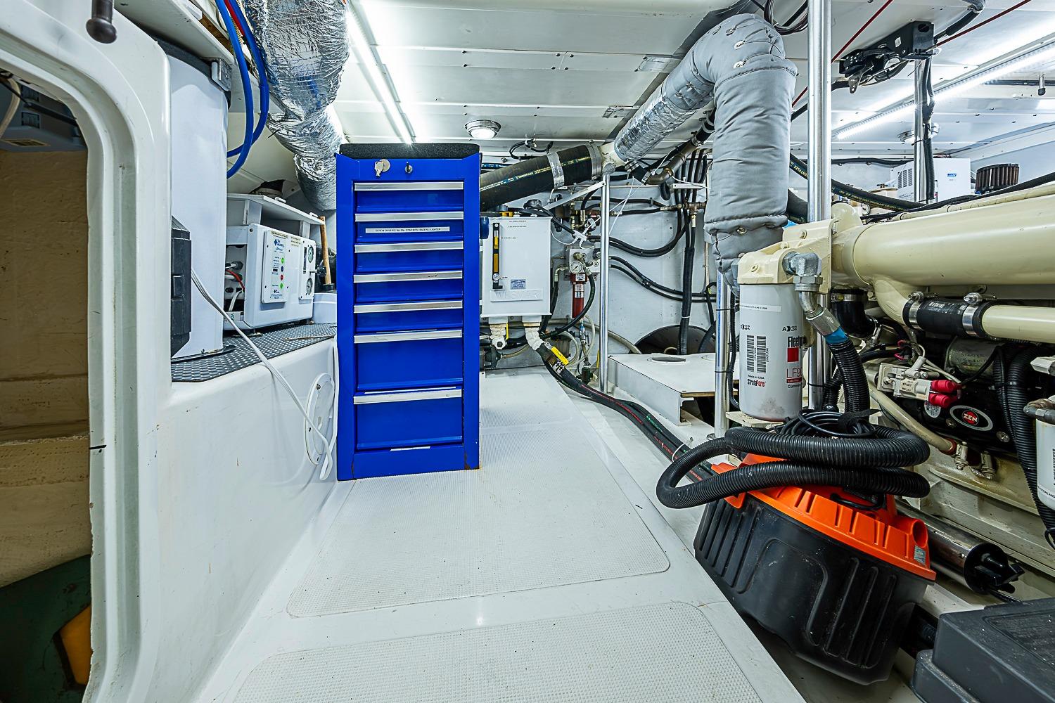 Engine room of 2003 Magna Marine Nova Scotia 47 with blue tool cabinet and machinery.