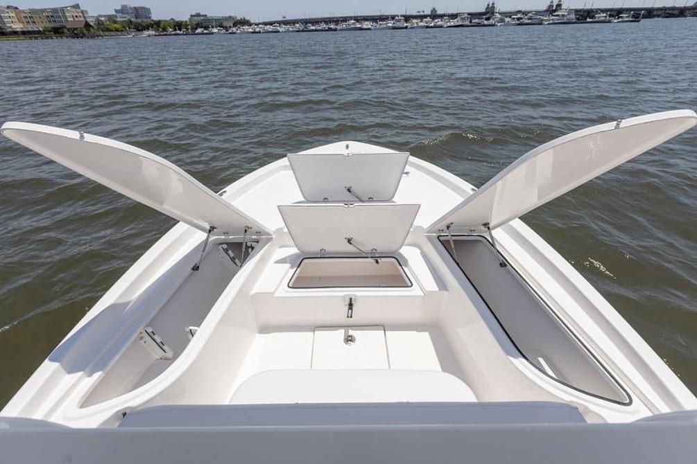 2027 Sea Fox 231 Bay Fox boat with open storage compartments on calm water.