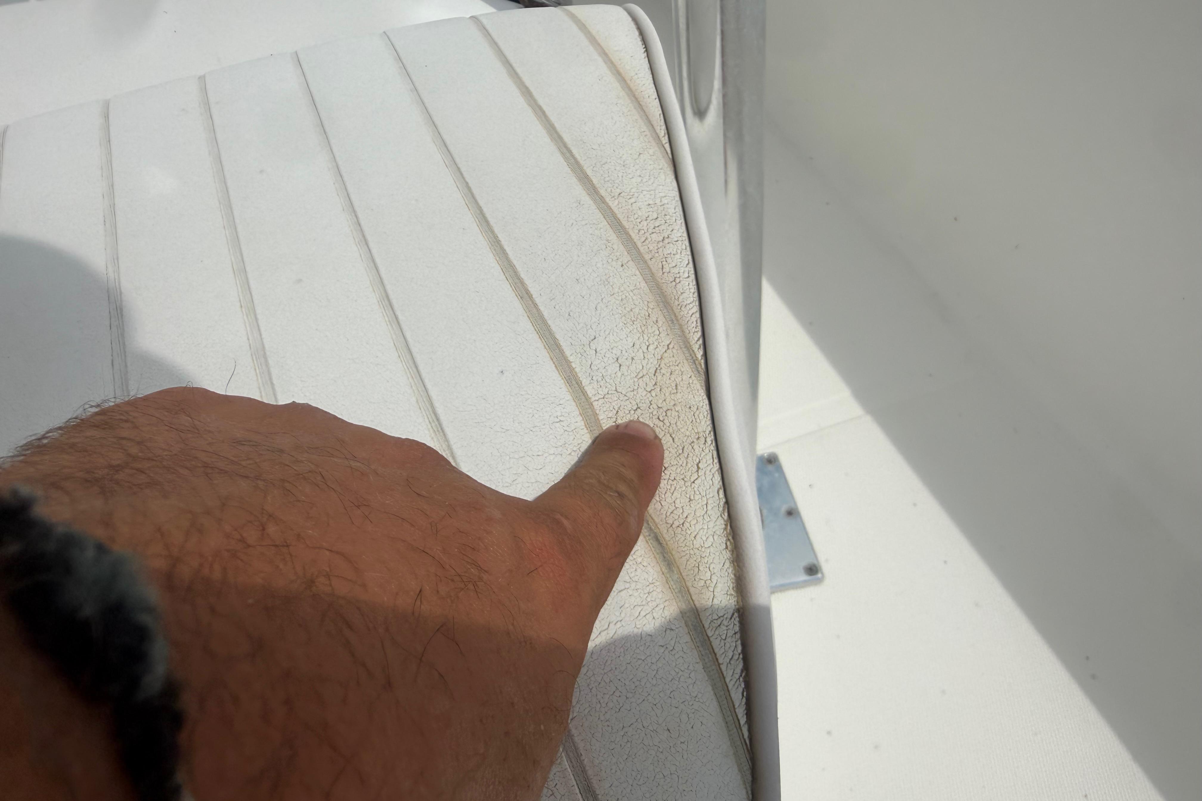Close-up of a hand pointing at textured surface on 2012 Clearwater 2000 Center Console boat.