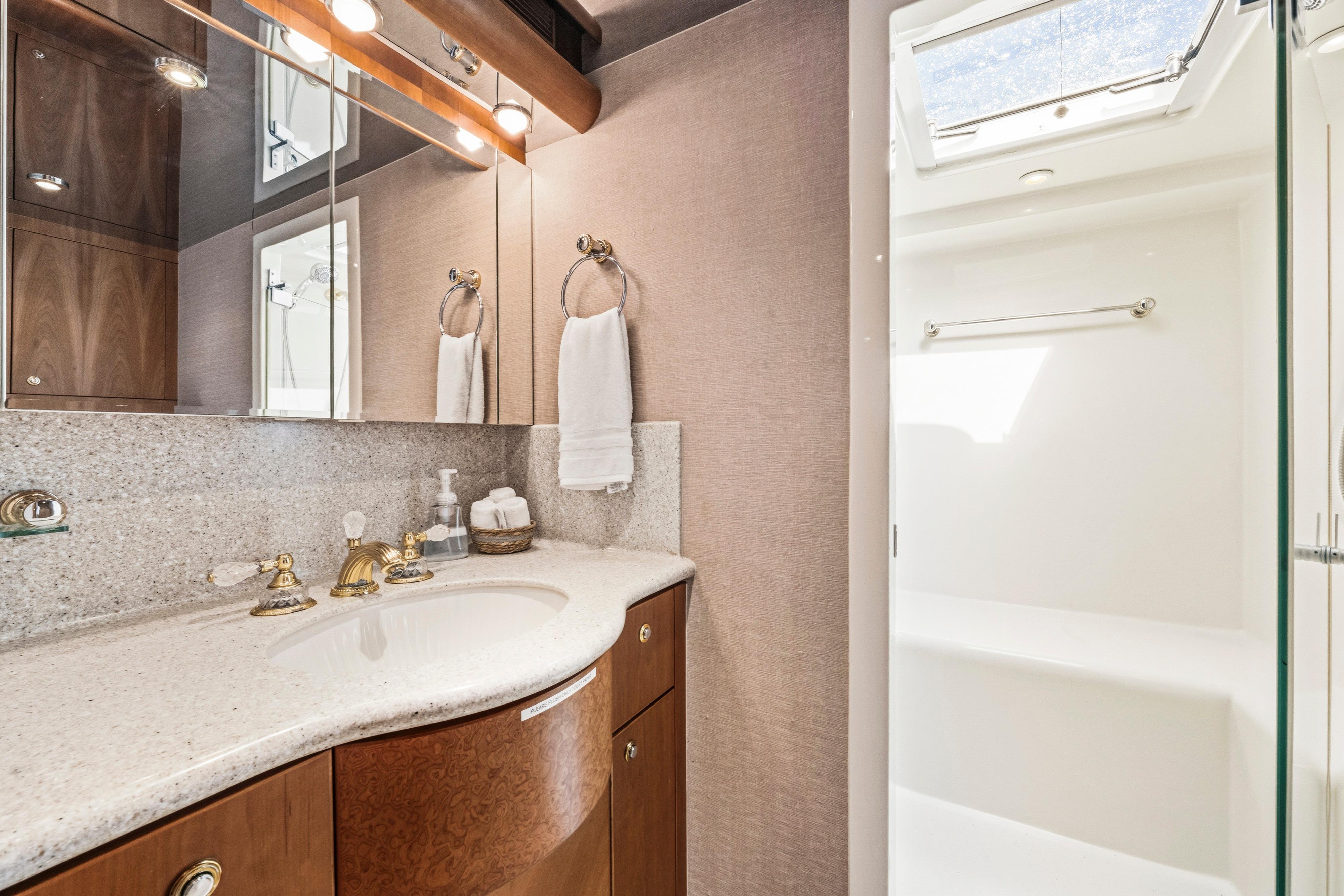 Luxurious bathroom in 2006 Cheoy Lee 84 Bravo yacht with elegant fixtures and skylight.