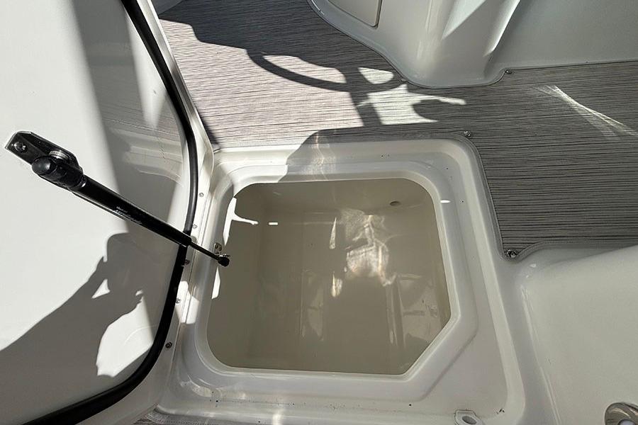 2027 Sea Ray SDX 230 Outboard storage compartment with open hatch and hydraulic support.