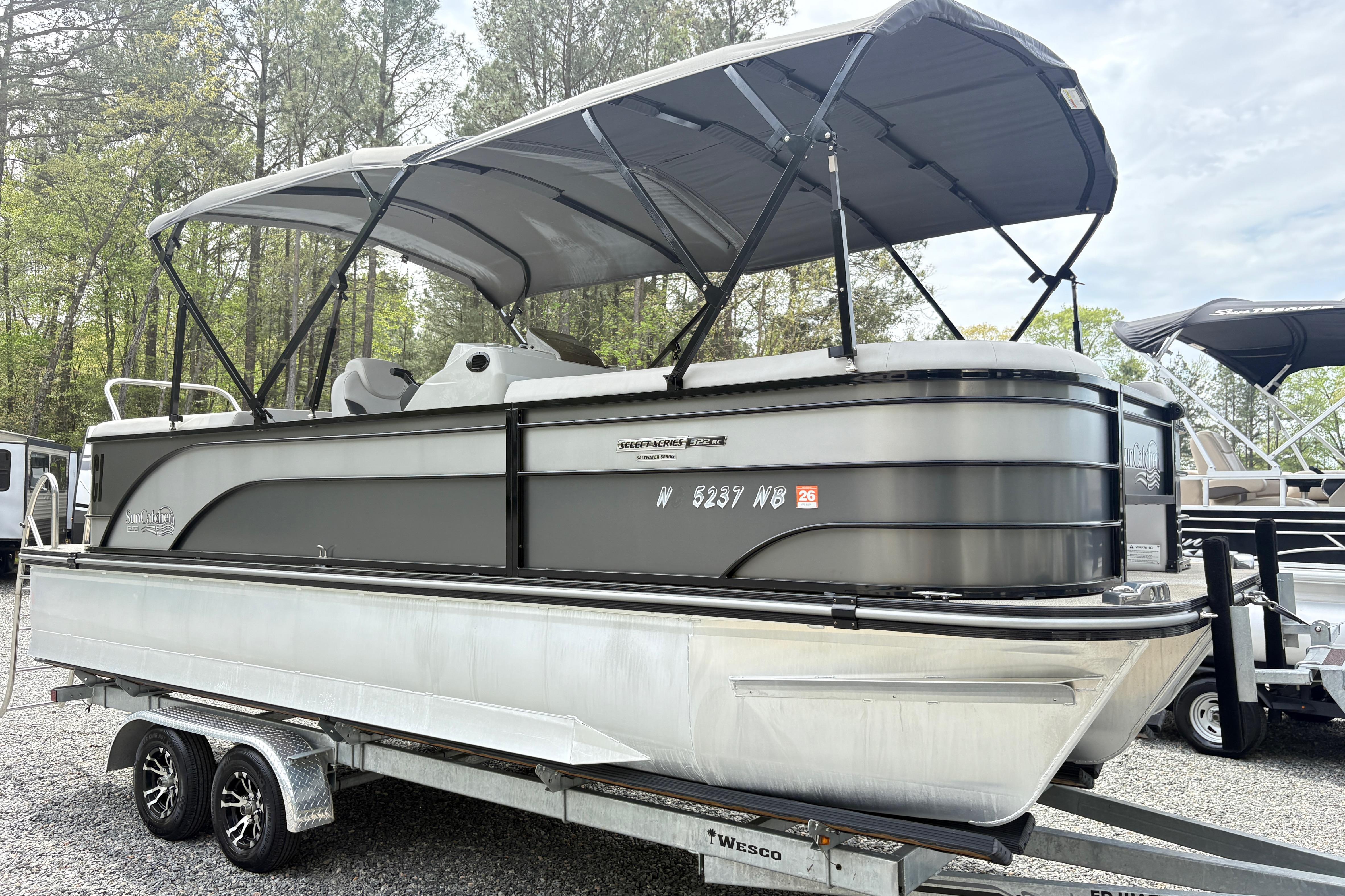 2023 SunCatcher X322 RC pontoon boat on trailer, parked outdoors.