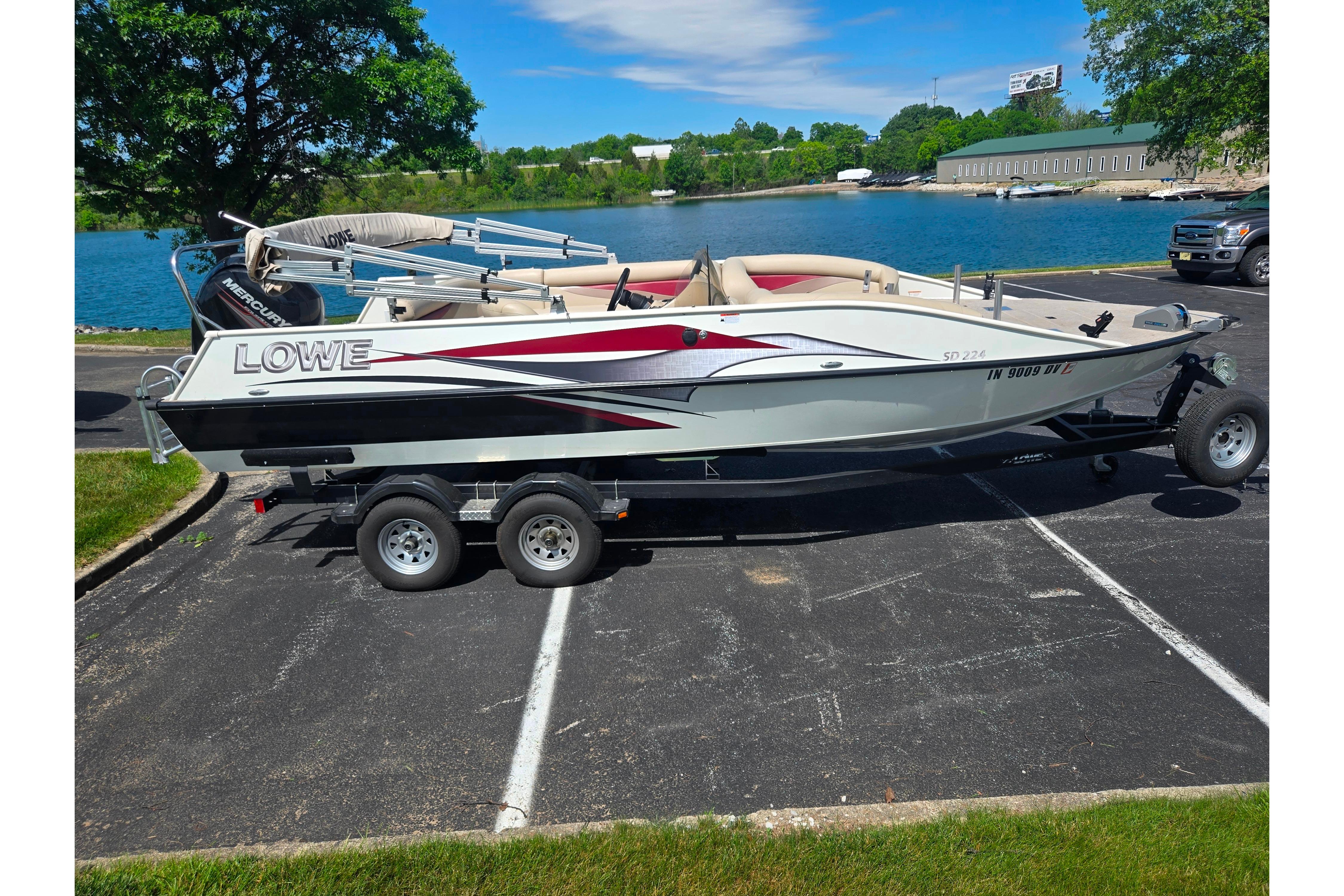 2015 Lowe Sport Deck 224 boat on trailer by a scenic lake.