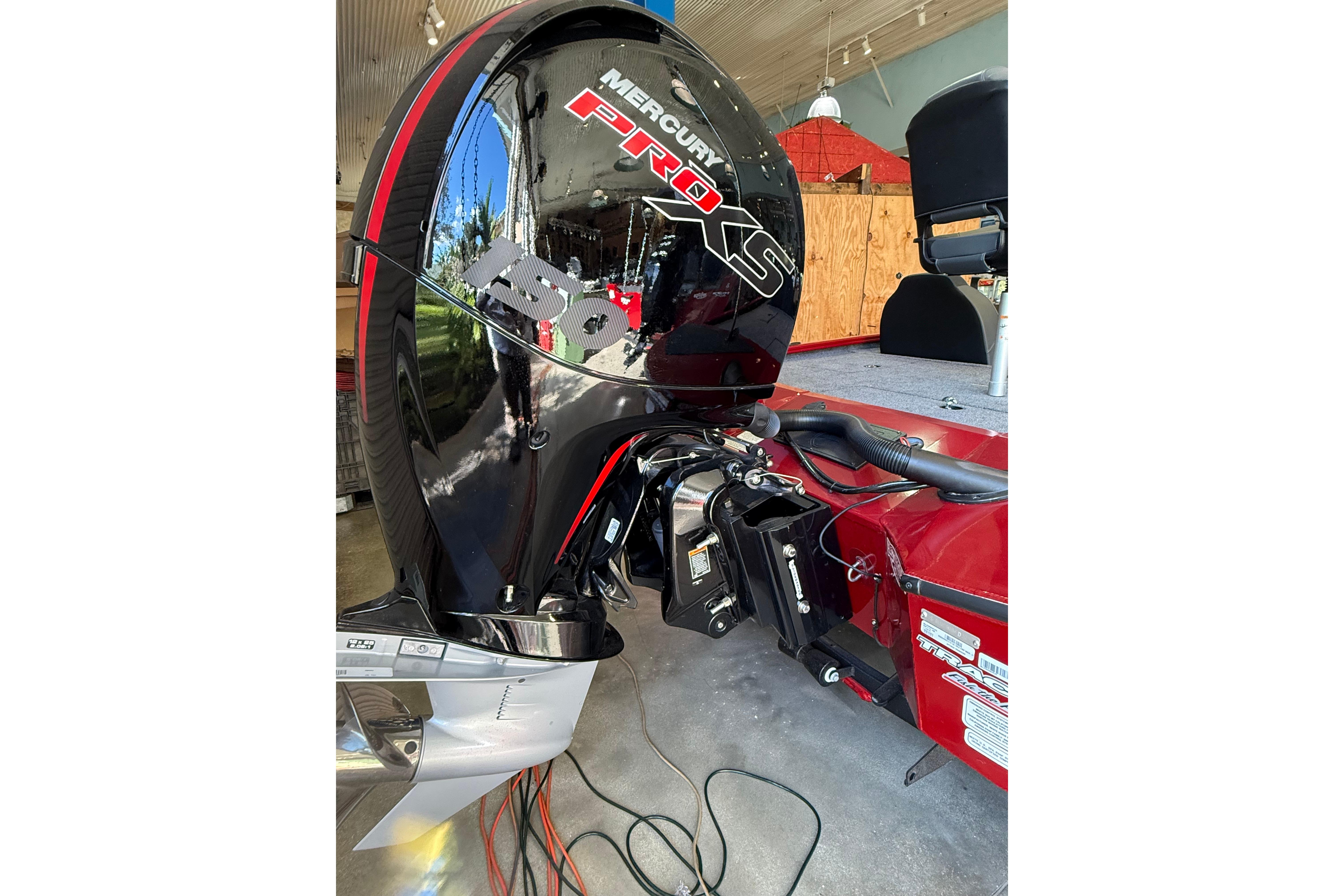 2025 Tracker Savage 215 boat with Mercury Pro XS engine in a garage setting.