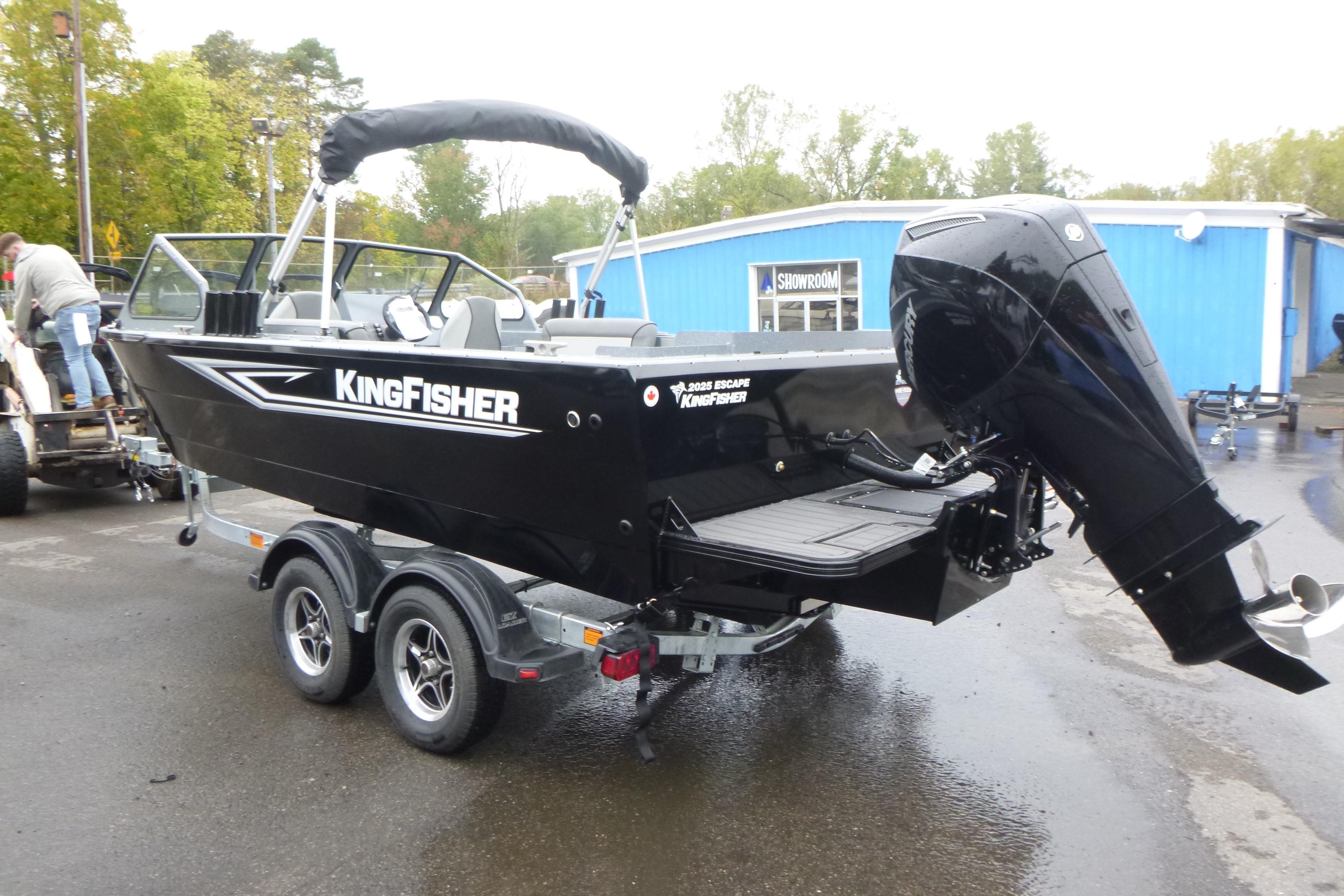 2026 KingFisher 2025 Escape boat on trailer, parked outdoors near blue building.