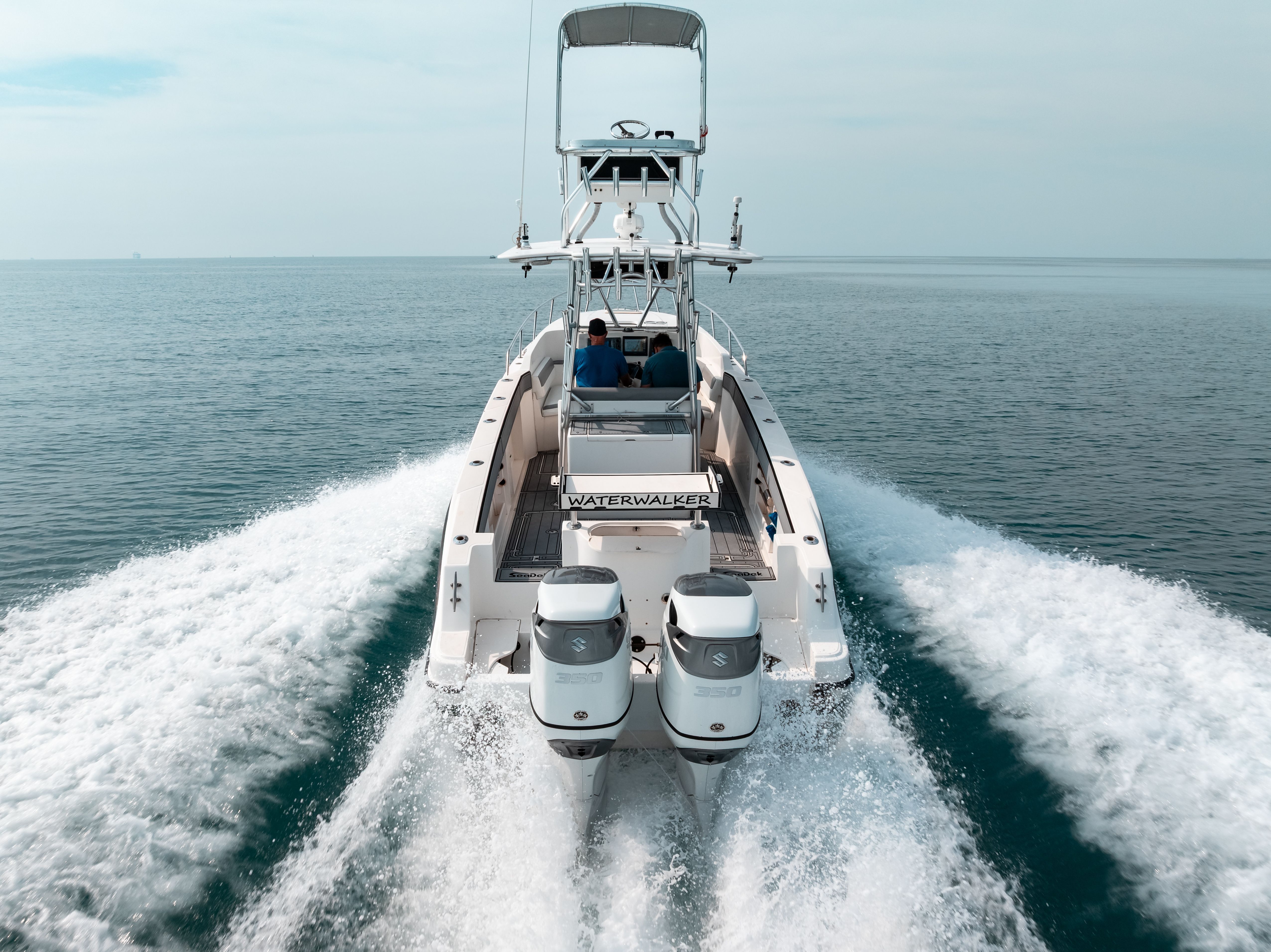 A 2006 Tempest Offshore 40 boat speeds across the sea, featuring twin engines and an elevated helm.