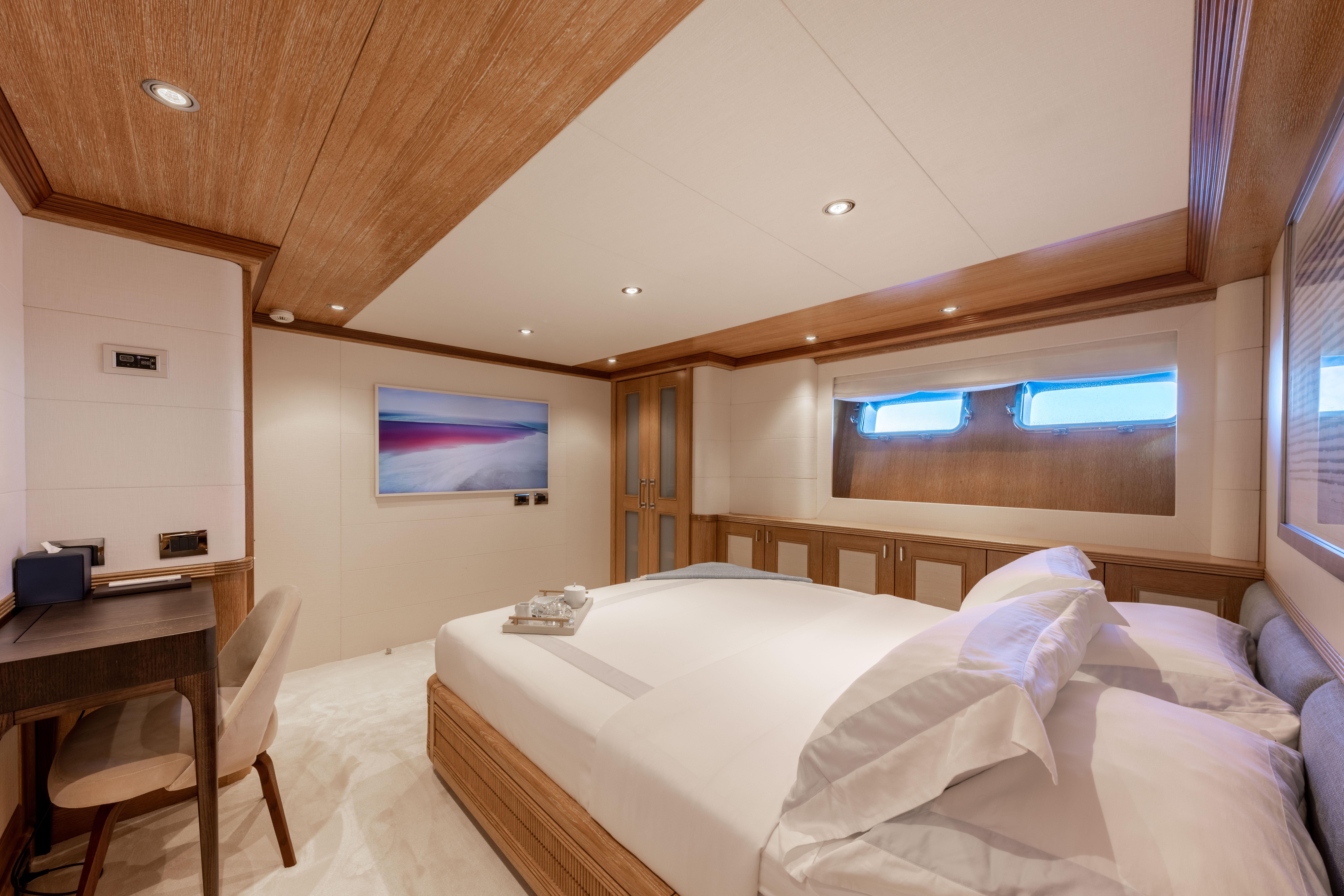 Luxurious Benetti yacht bedroom, 1995 model, featuring elegant wood paneling and modern decor.