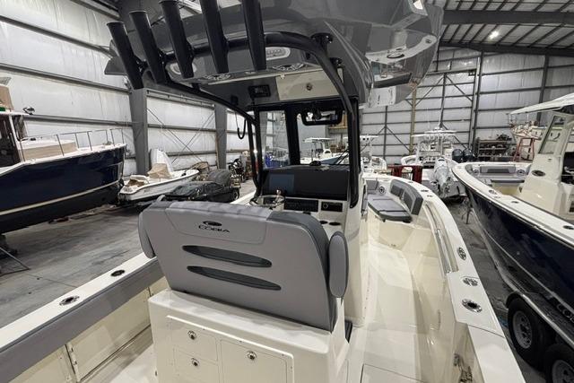 2026 Cobia 245 Center Console boat in a spacious indoor showroom.