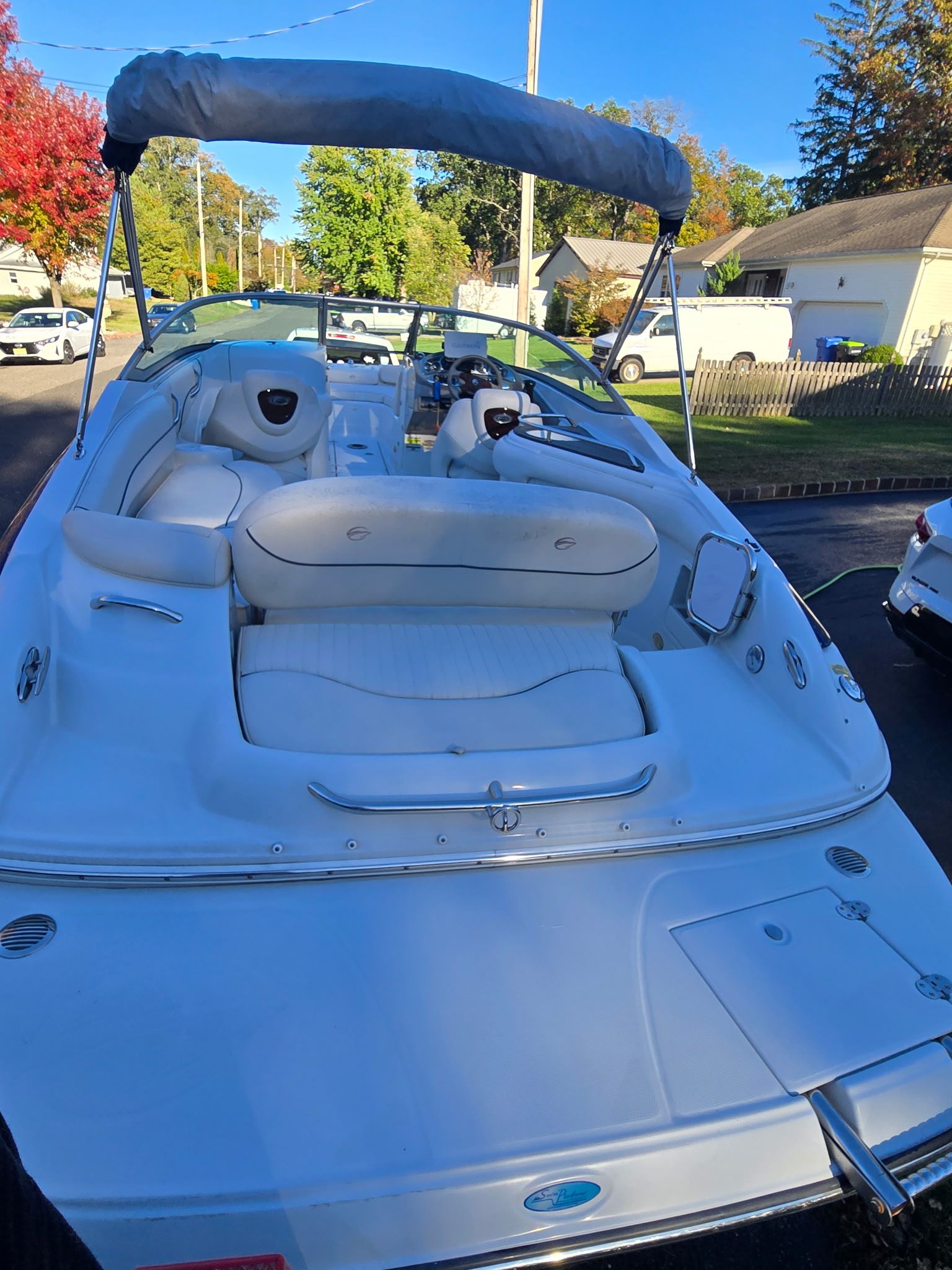 A white 2005 Crownline 240 EX boat with a sunshade and cushioned seating.