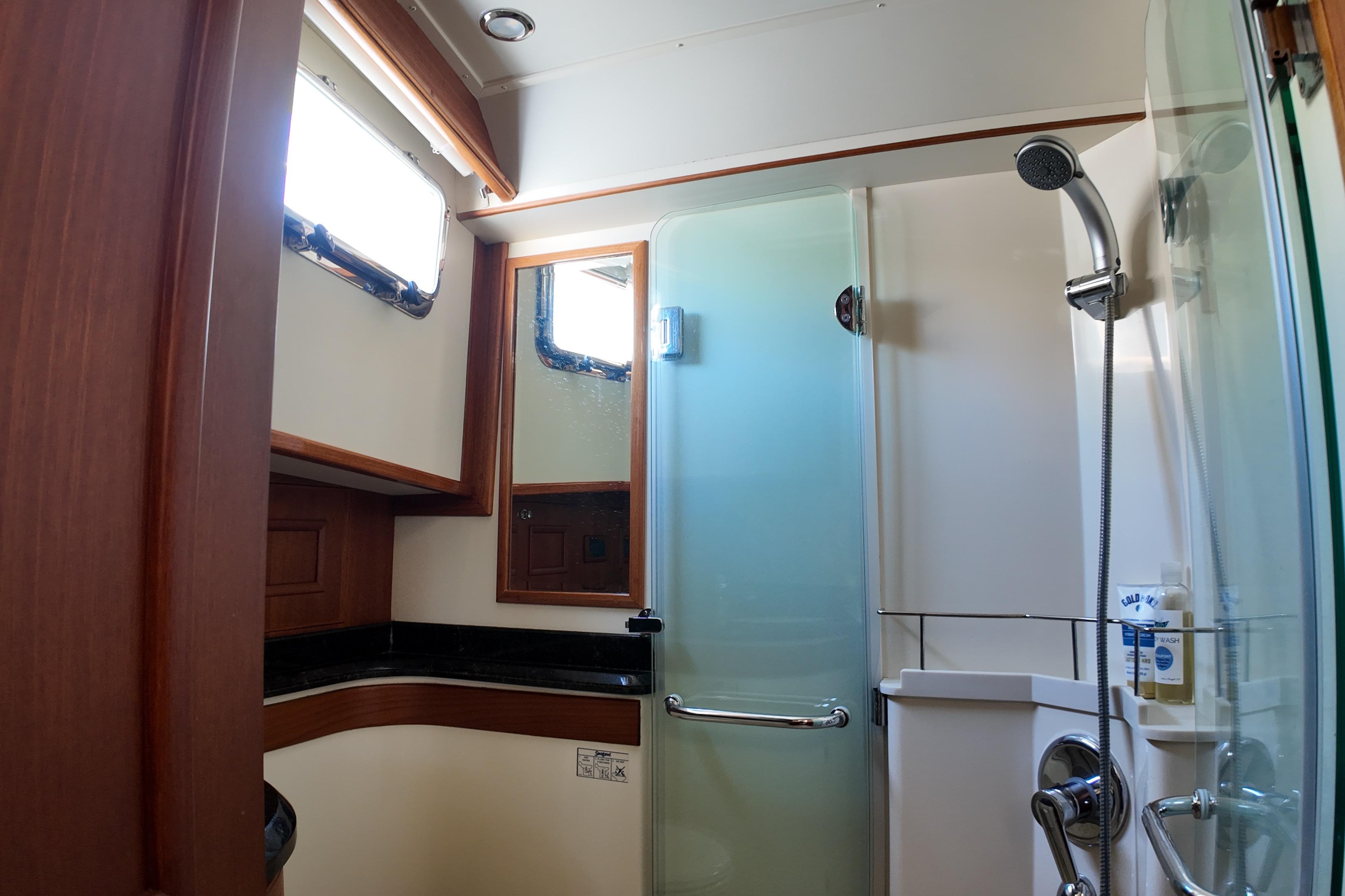 Luxurious bathroom in 2009 Grand Banks 47 Heritage CL yacht with shower and wooden accents.