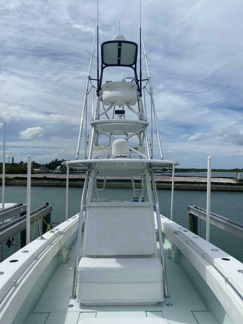 2012 Contender 39ST boat with tower, docked under a cloudy sky.